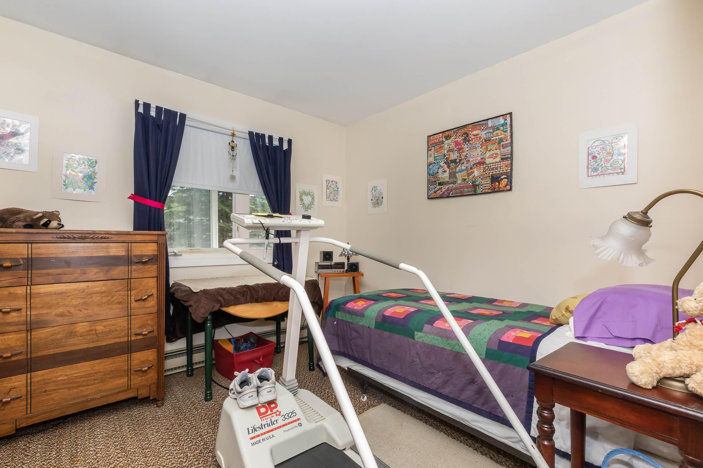 a bedroom with a bed and desk in a room