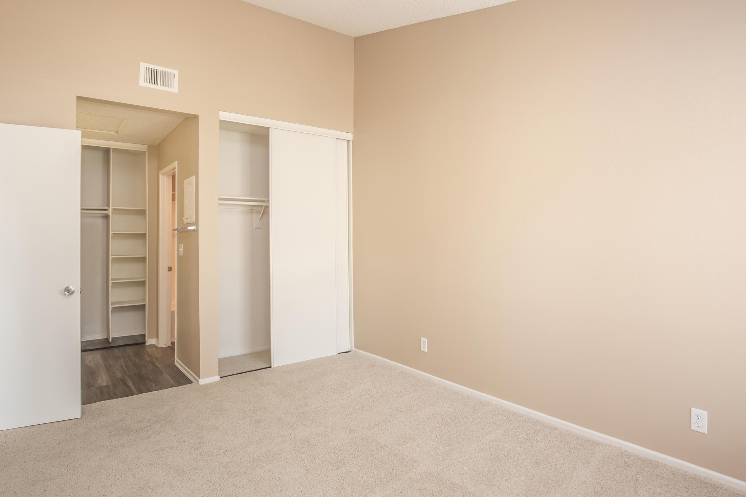 Bedroom with open closet and bathroom doors