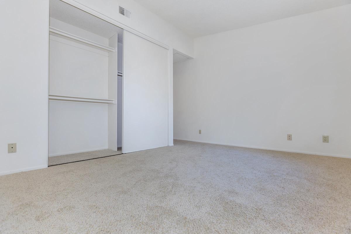 Carpeted bedroom with open sliding closet door