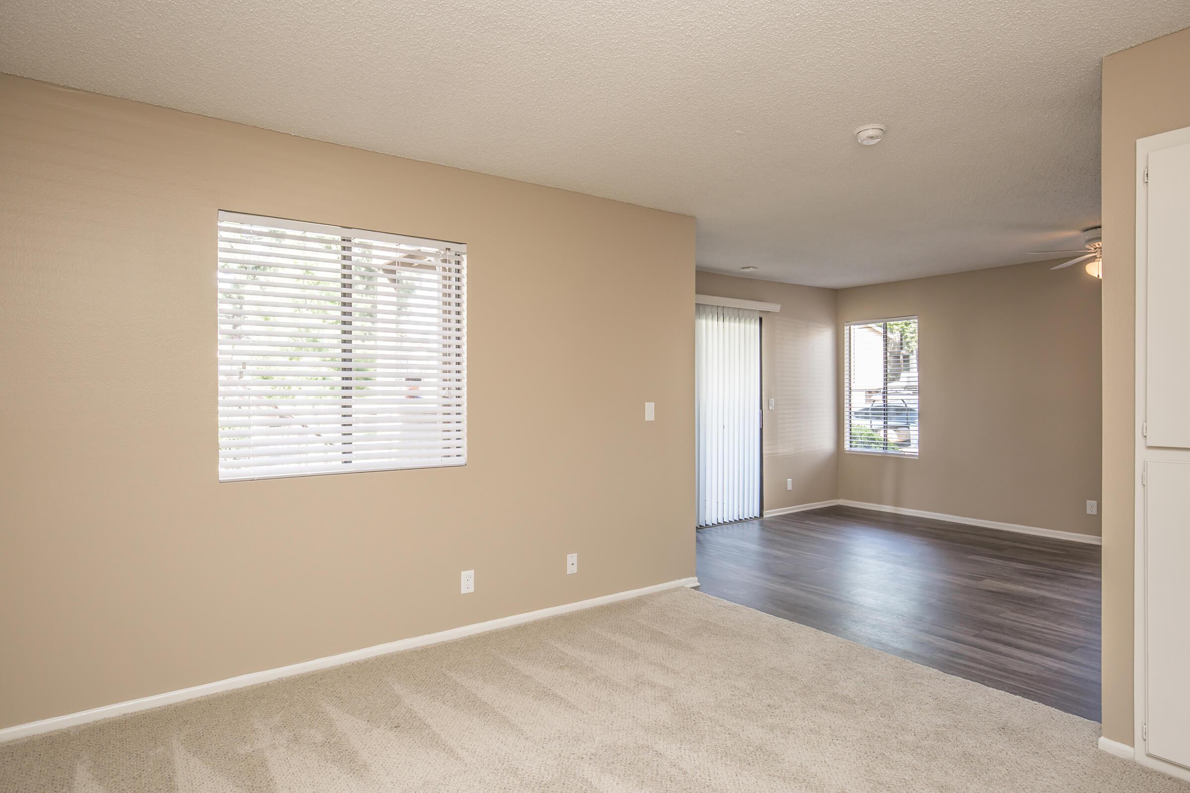 Unfurnished carpeted living room and dining room with wooden floors