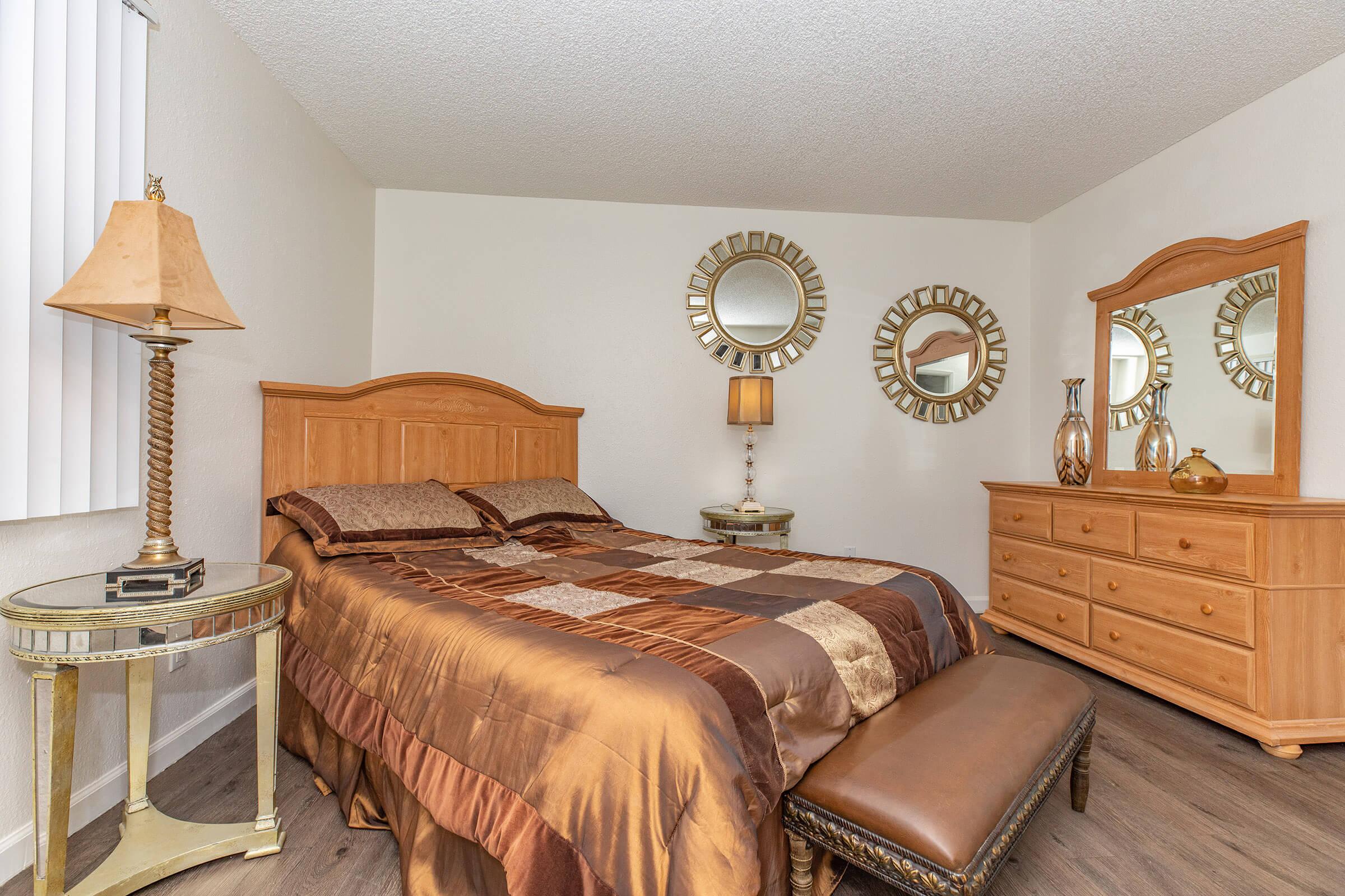 a bedroom with a bed and desk in a hotel room