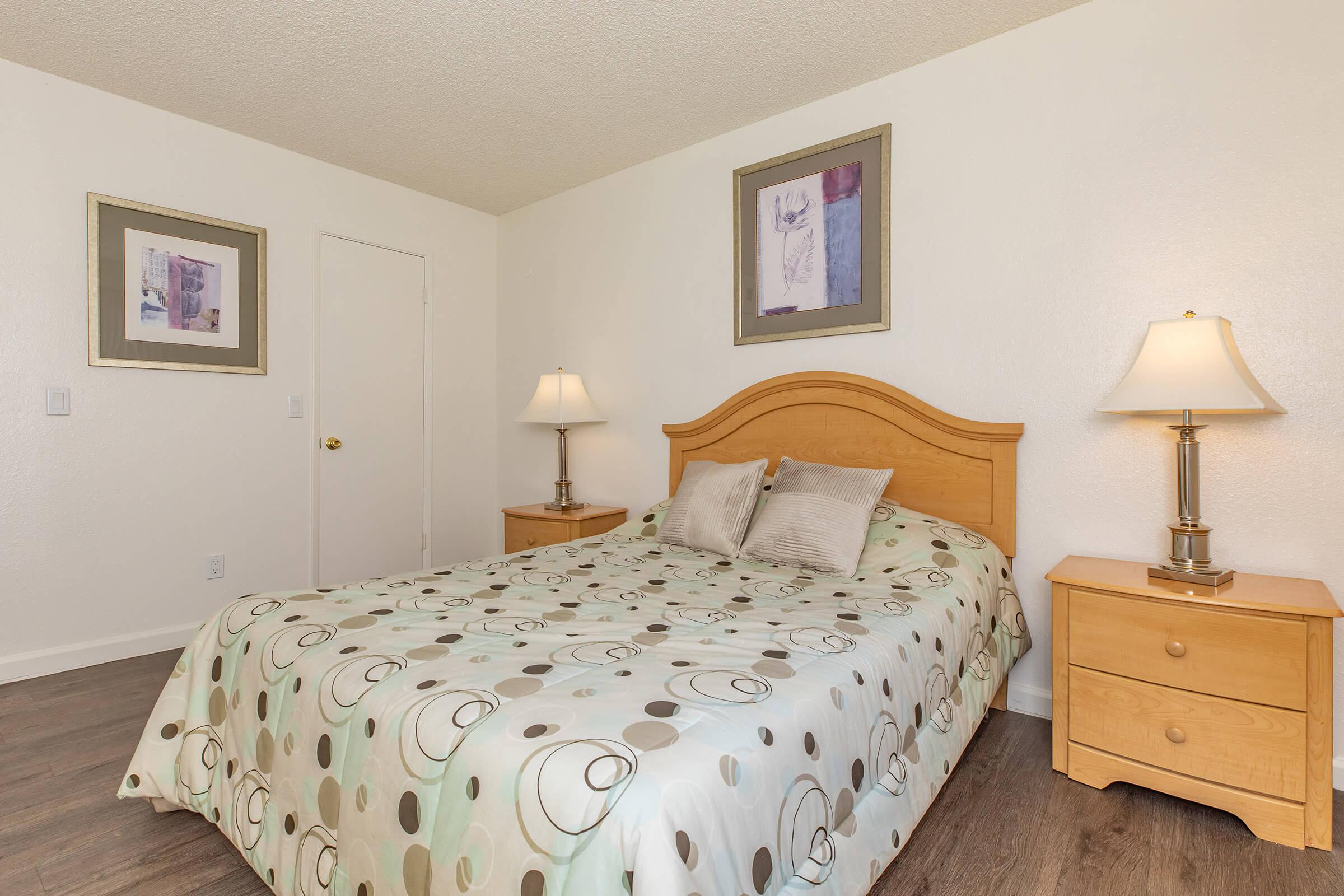 a bedroom with a bed and desk in a hotel room