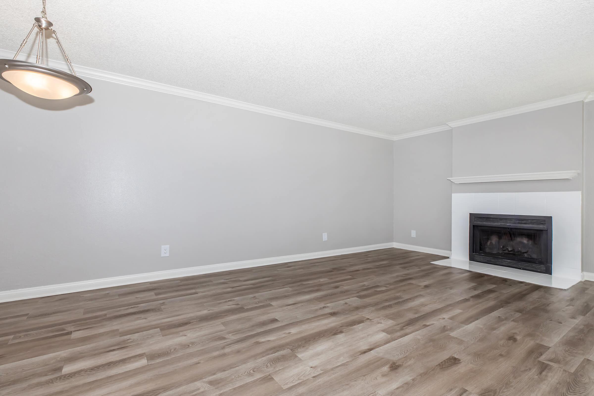 Luxury Apartments In Riverside, CA With In-Unit Washer And Dryer - Canyon Crest Views - Spacious Living Room With Hardwood Floors, A Fireplace, And High Ceiling