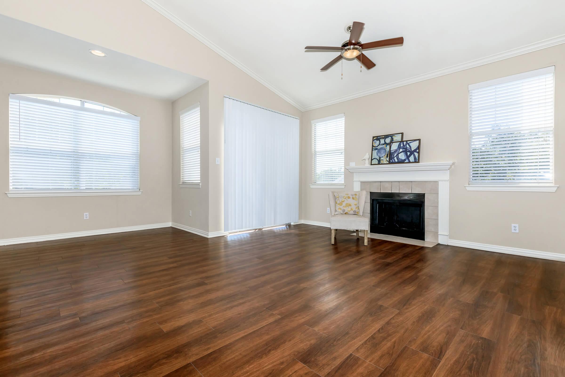 a living room with hard wood flooring and a large window