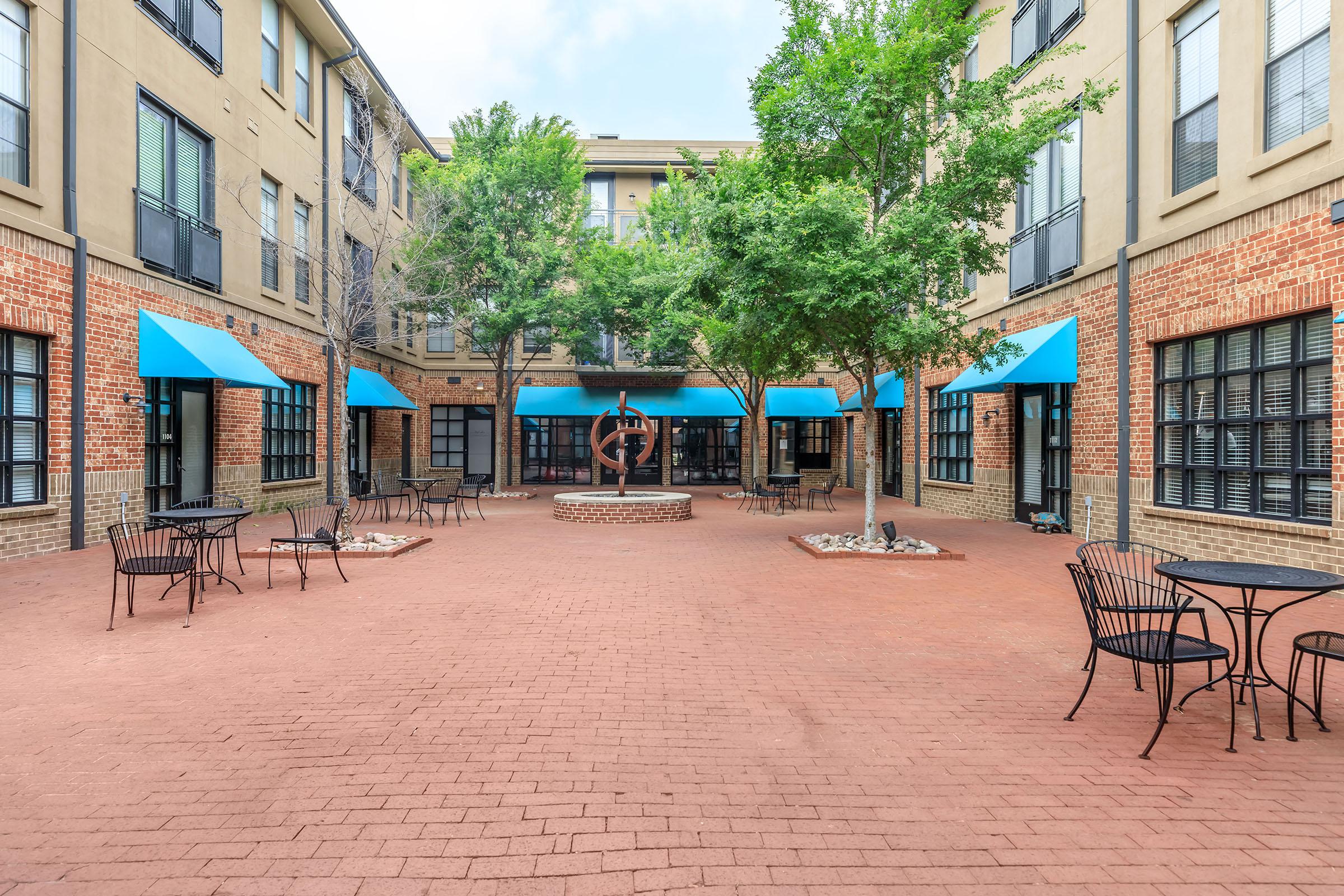 a group of people walking in front of a brick building