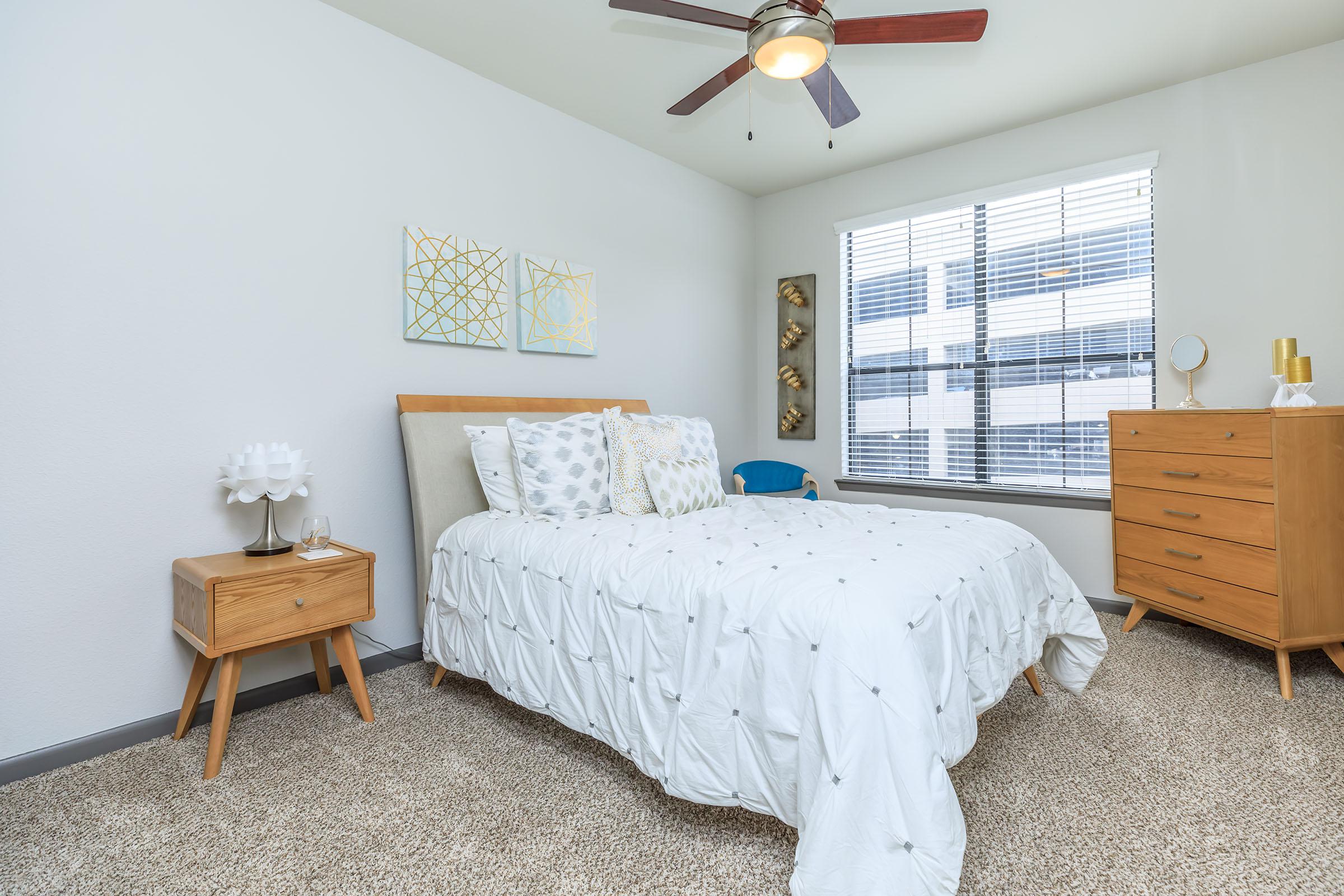 a bedroom with a bed and desk in a room