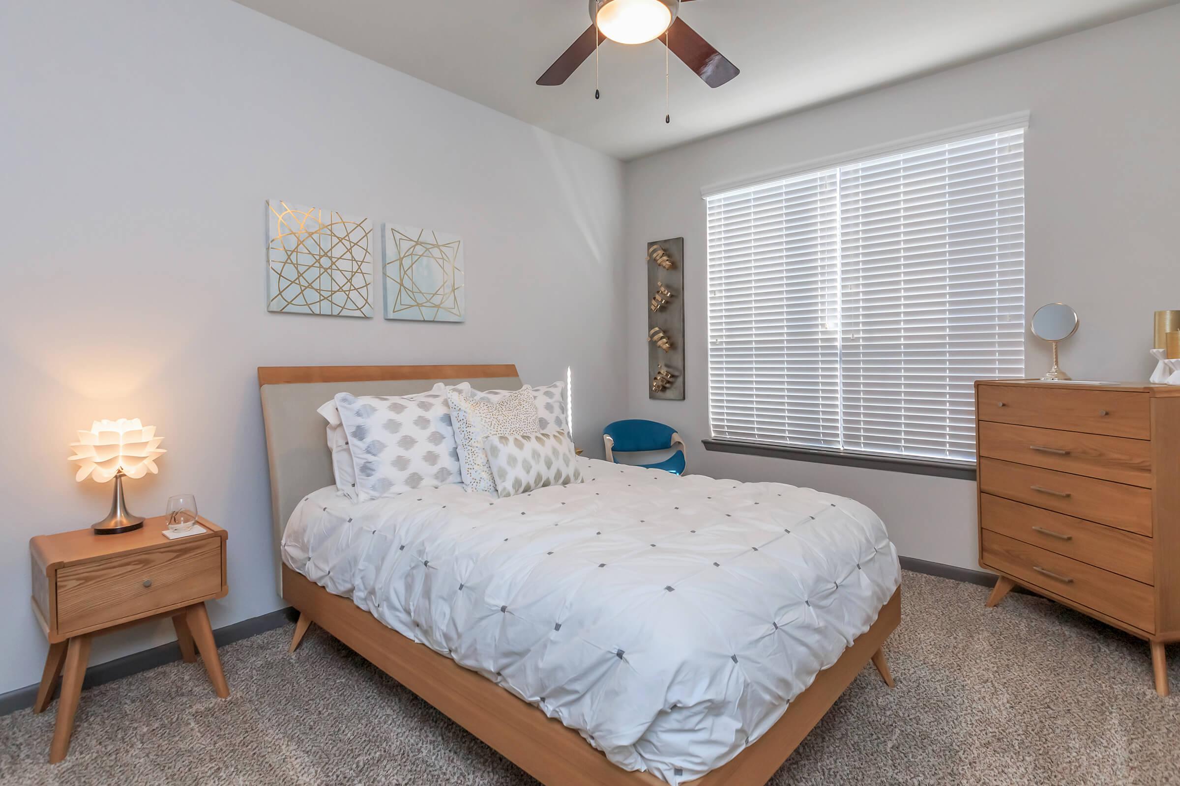 a bedroom with a bed and desk in a room