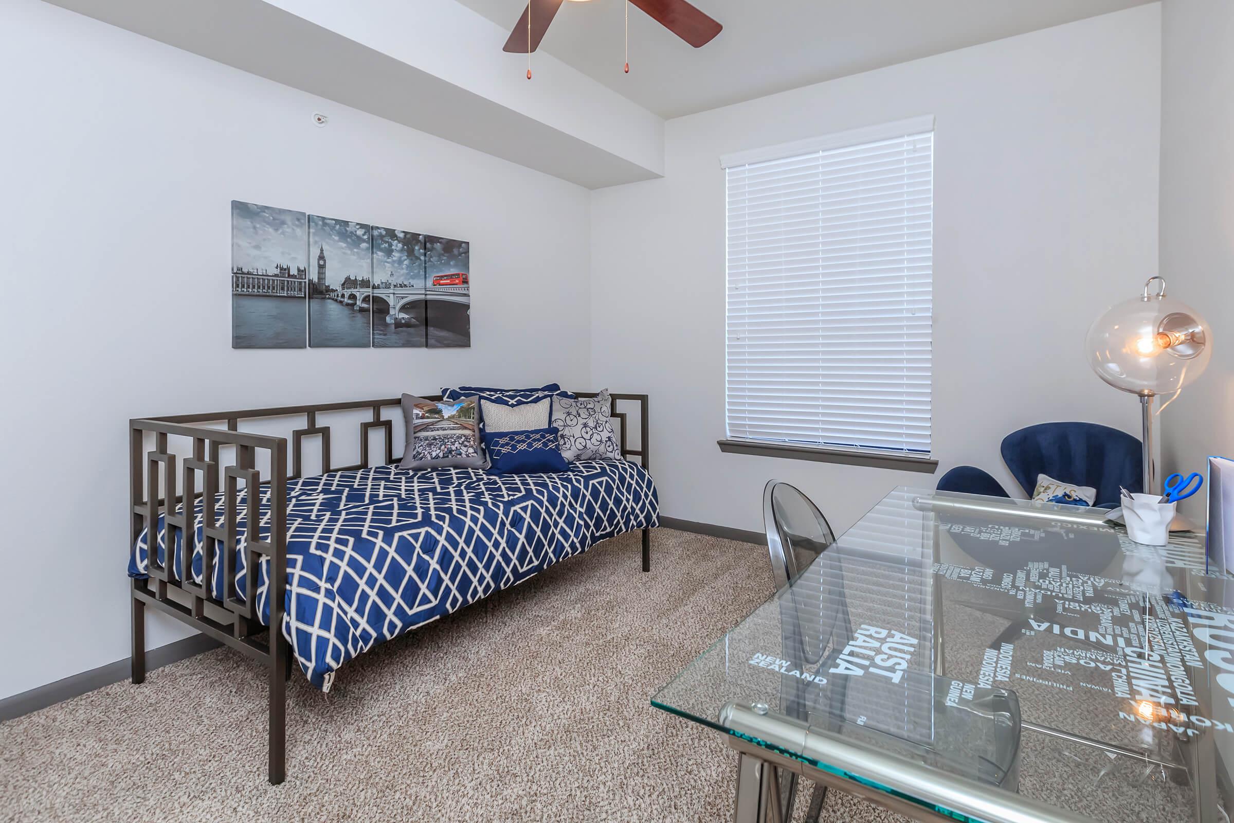 a bedroom with a bed and a chair in a room