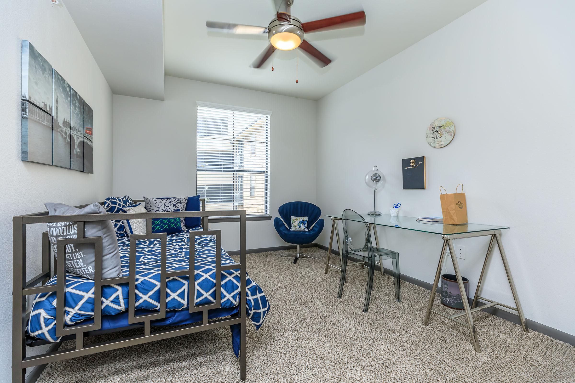 a bedroom with a bed and a chair in a room