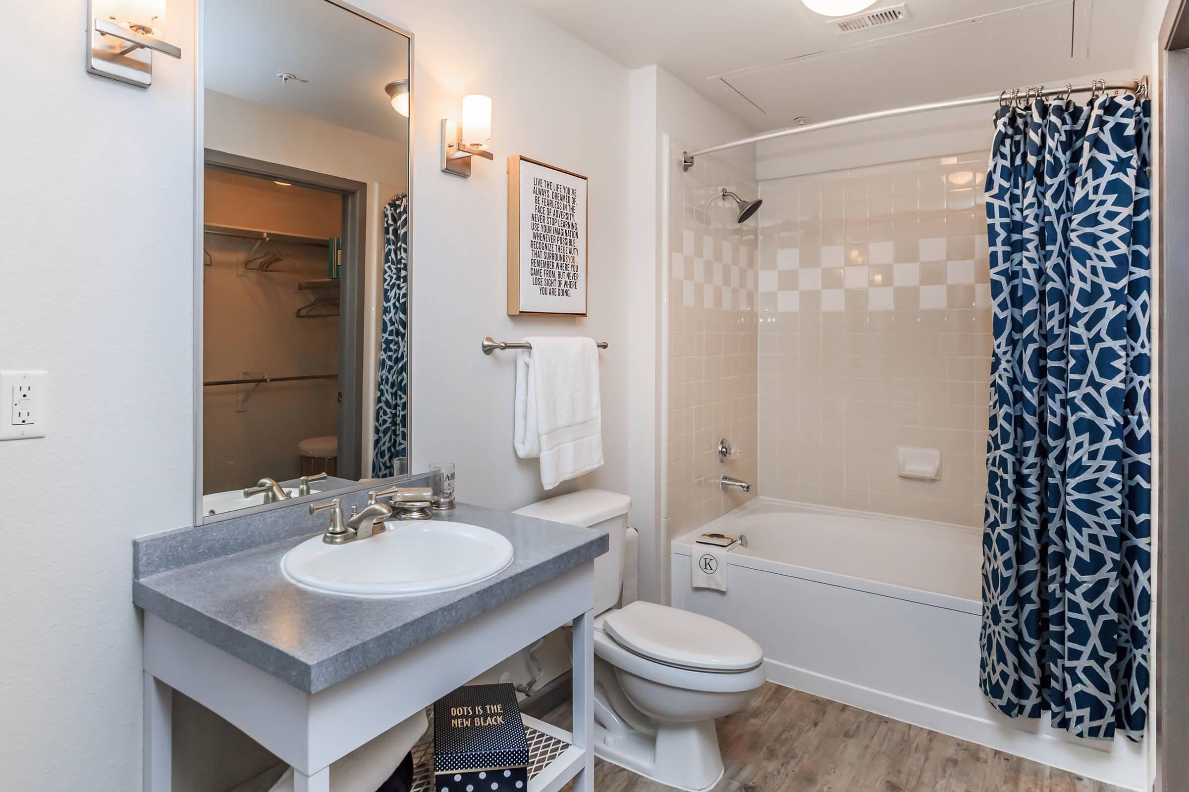 a white sink sitting under a mirror