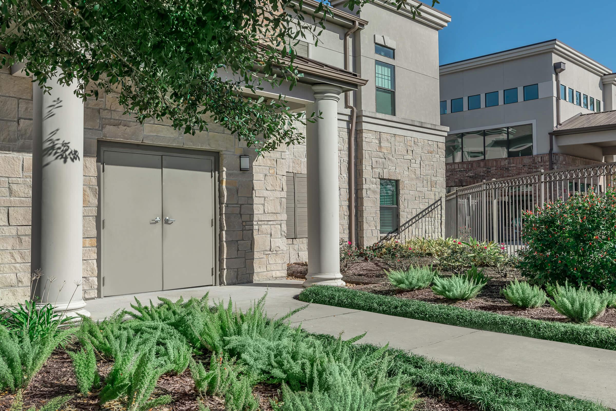 a house with bushes in front of a building