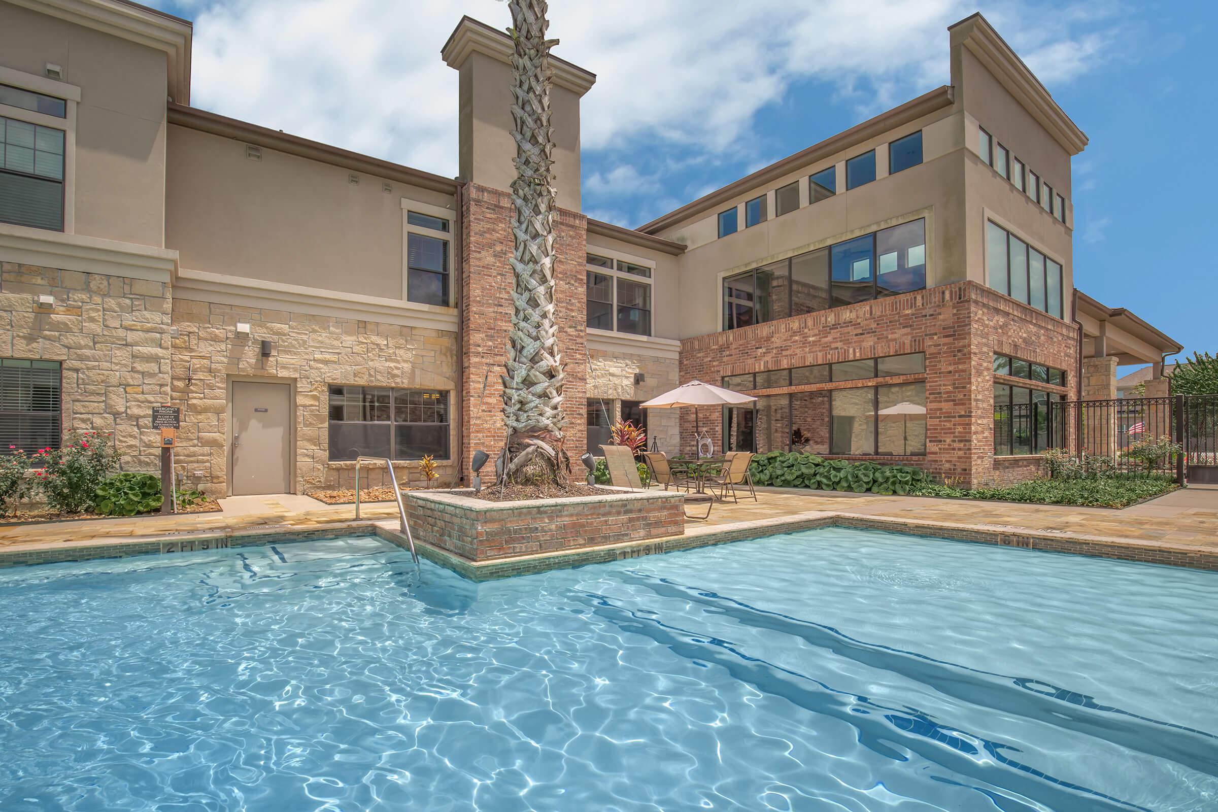 a large brick building with a pool of water