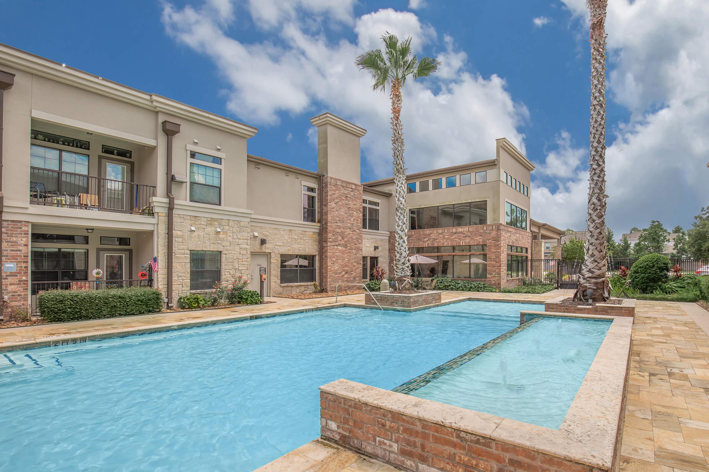 a large brick building with a pool in front of a house