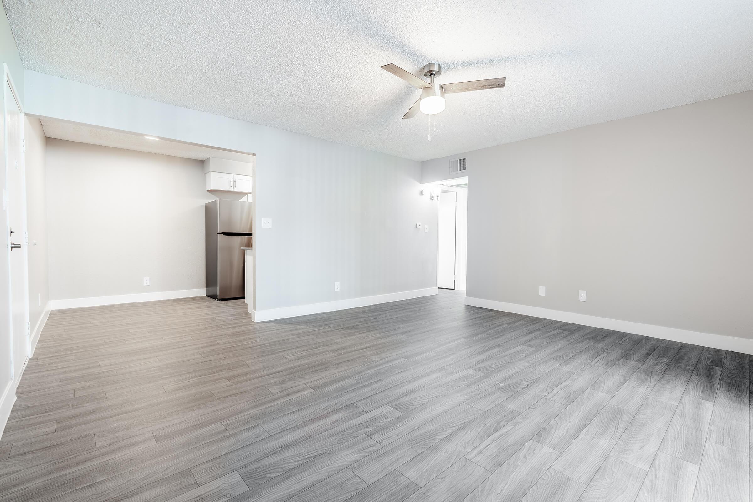 Modern open floor plan living room with wood flooring and ceiling fan