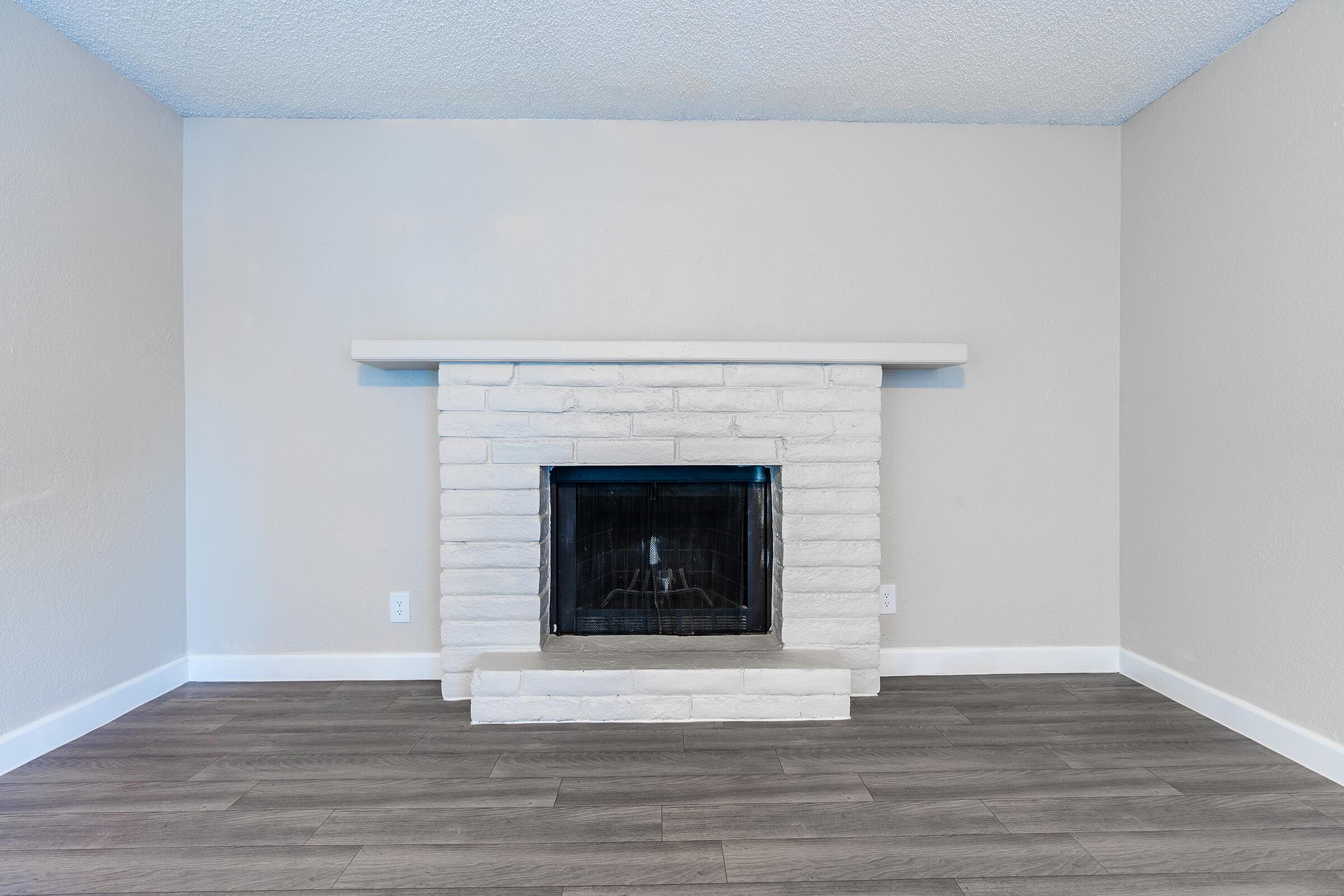 White brick fireplace with mantel above in a large modern living room space