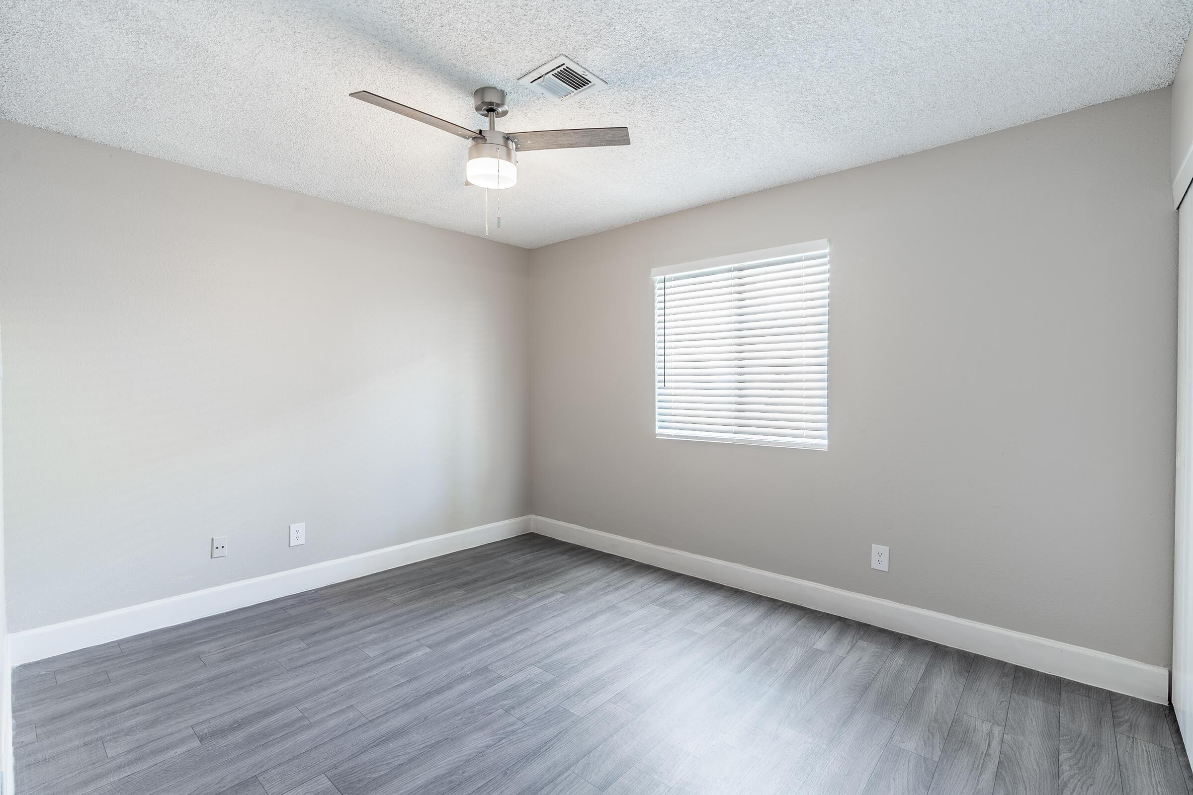 Modern empty bedroom with window and ceiling fan