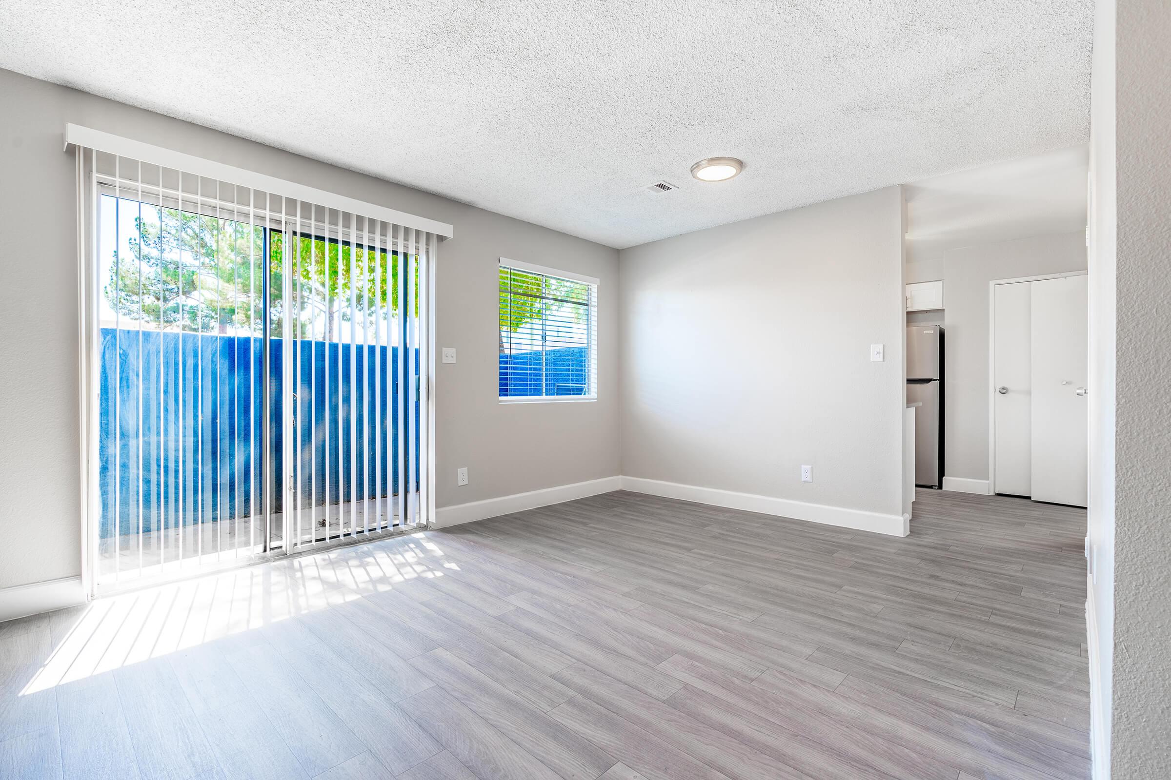 Glass sliding doors leading to a patio, next to a small open dining room area