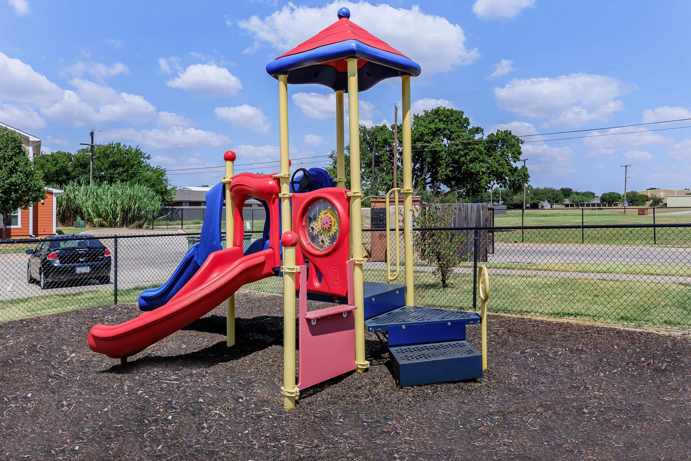 a playground with a blue umbrella