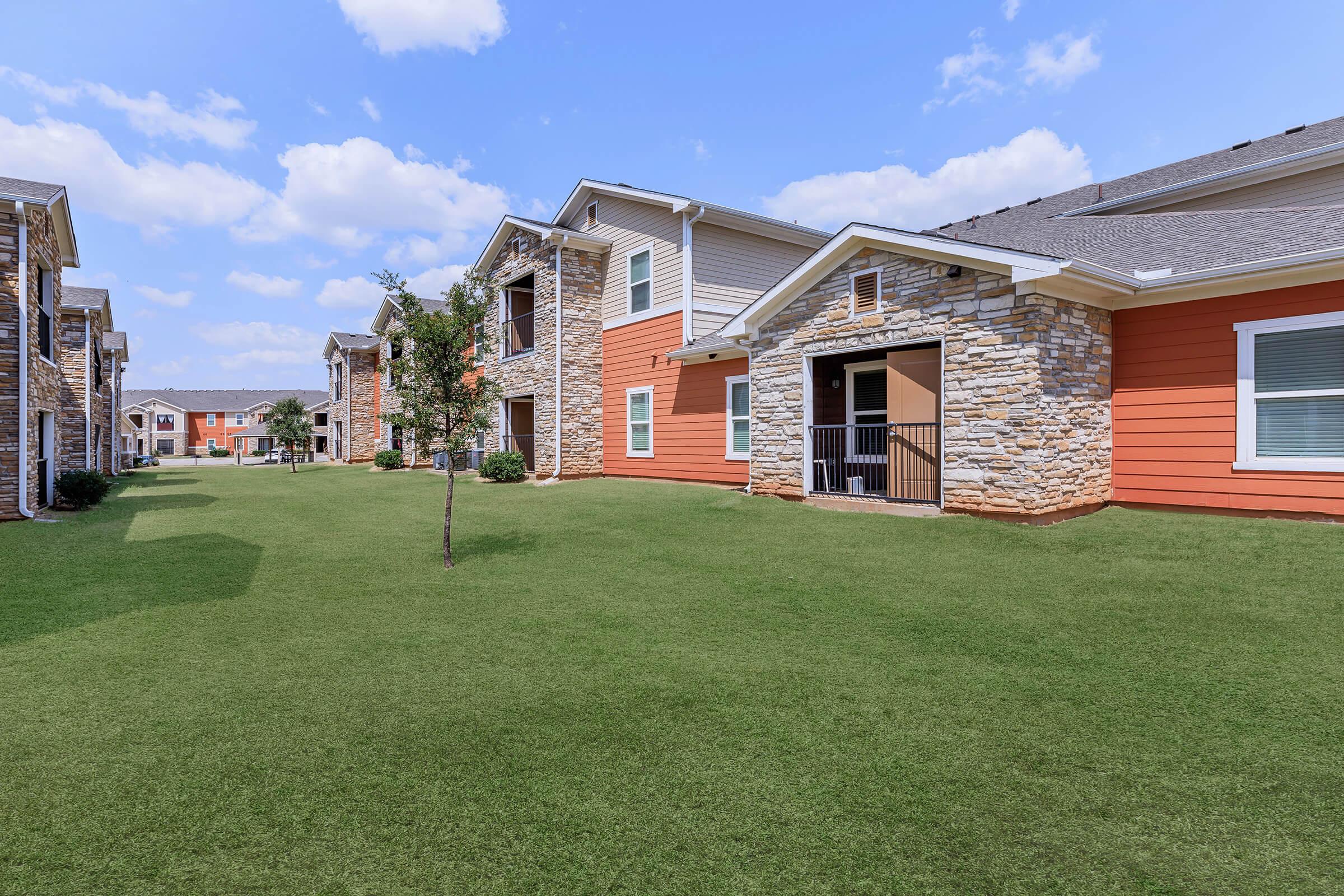 a large green field in front of a house