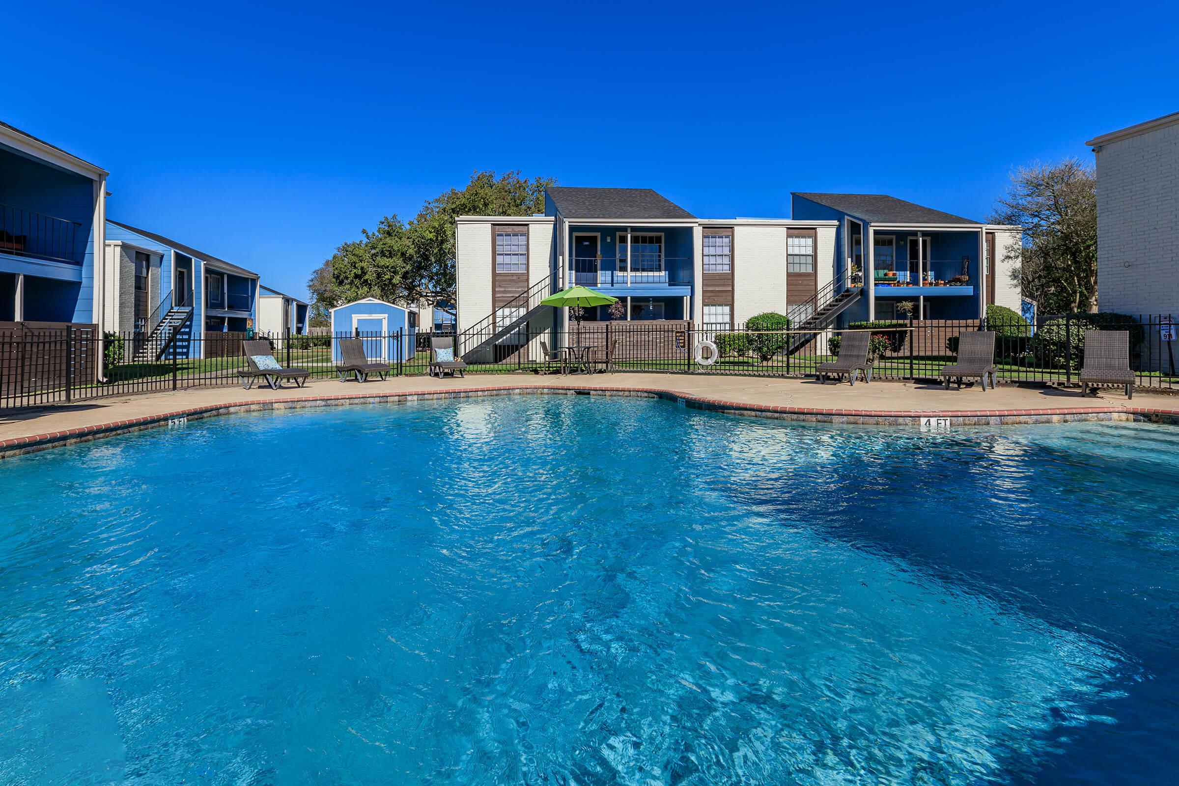 a blue pool of water in front of a house