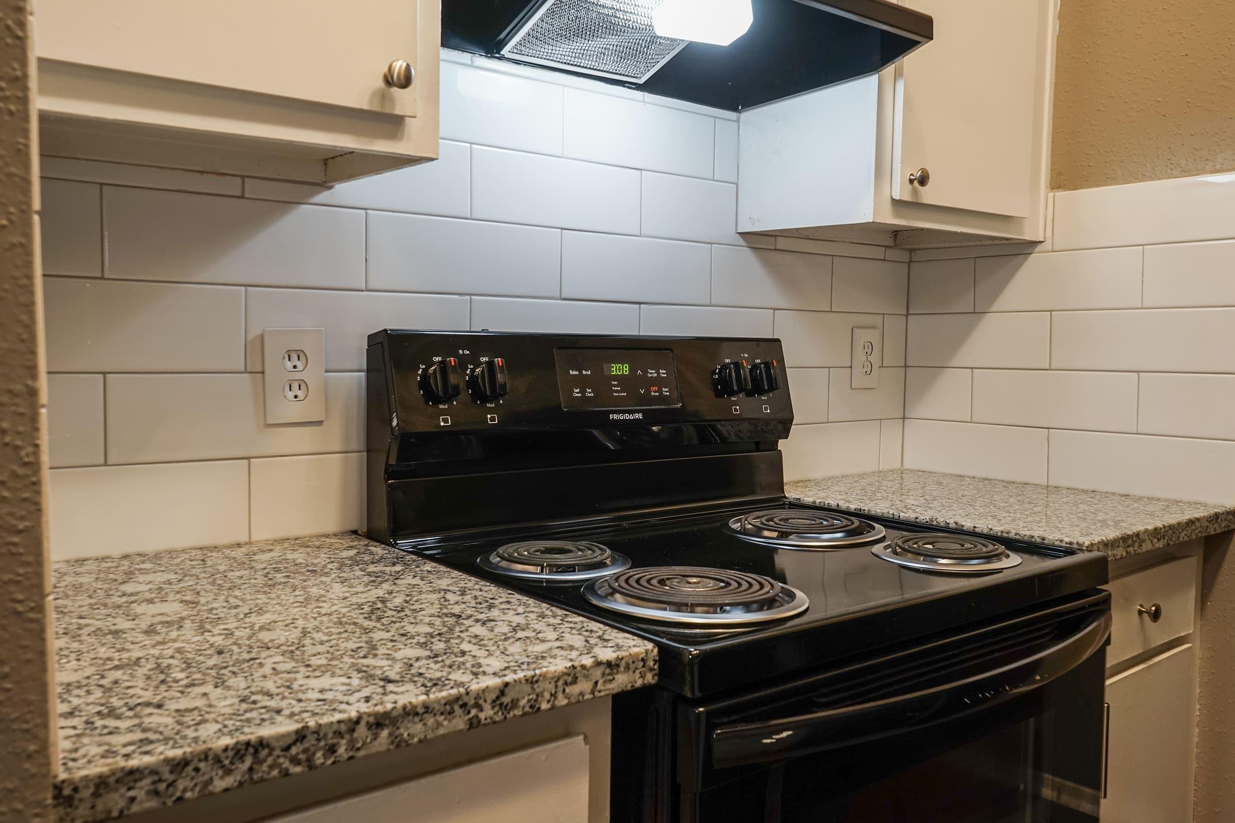 a stove top oven sitting inside of a kitchen