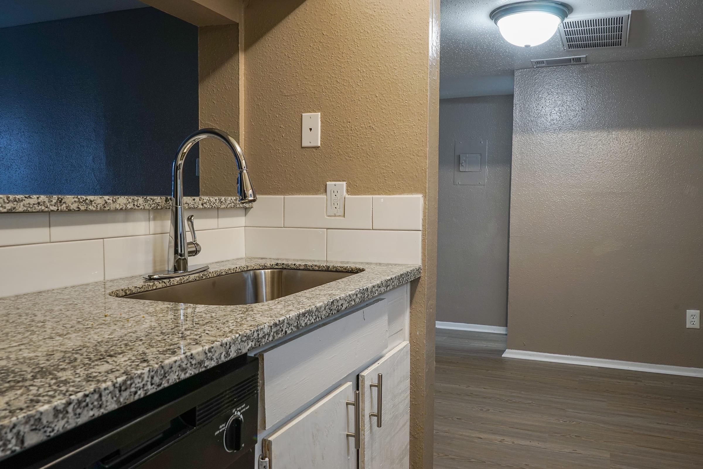 a kitchen with a sink and a mirror