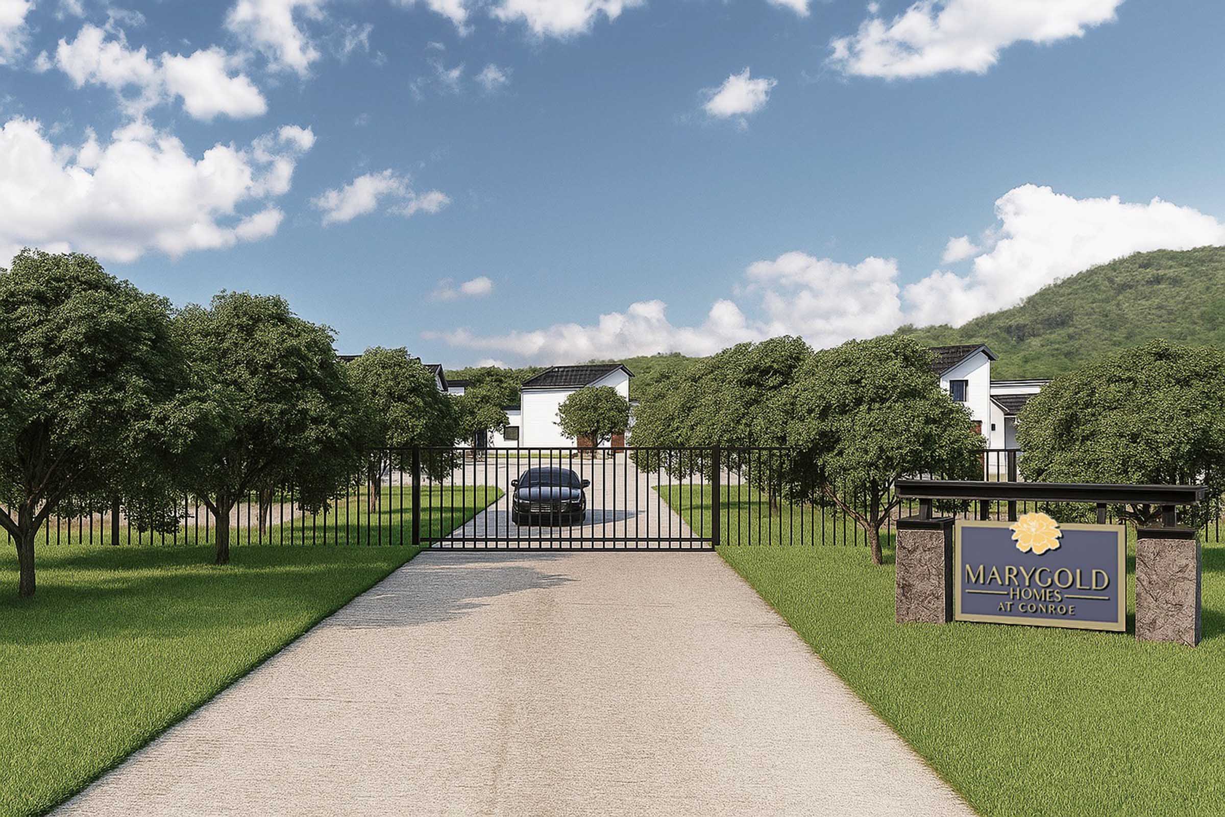 A gated entrance to a residential community named "Marygold Homes at Compass." The driveway is lined with trees, leading to houses in the background, with a blue sky and clouds overhead. A car is parked in front of the gate, which is closed, indicating a secure entry point to the neighborhood.