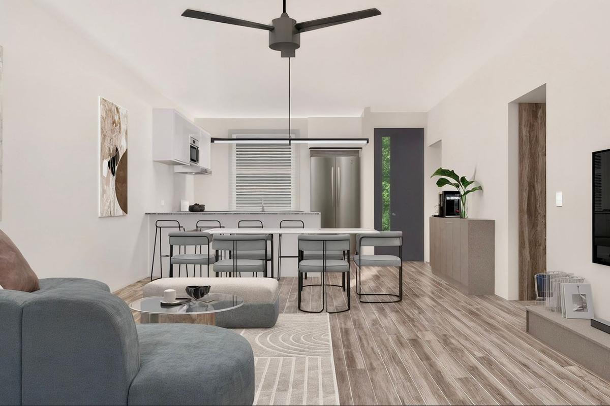 A modern and spacious interior view of a living and dining area featuring a stylish kitchen with a large island, dining table with six chairs, a cozy seating area with a sofa, and a minimalist design with natural light flowing through large windows. The flooring is wood-like, and decor elements are simple and elegant.