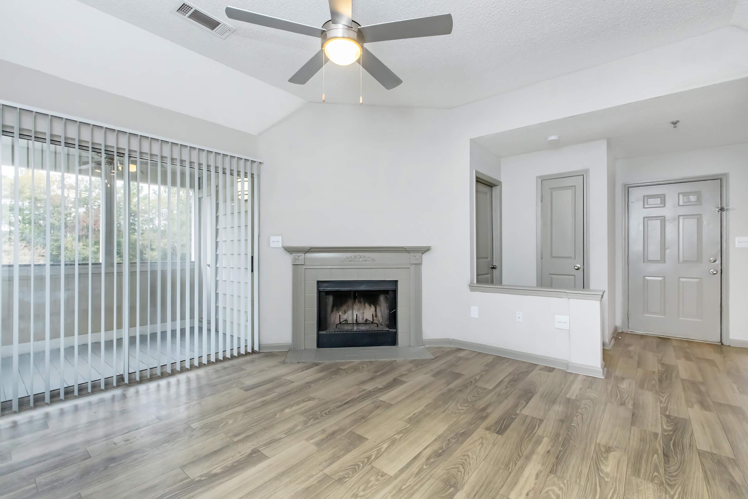 a living room with a fireplace and a large window