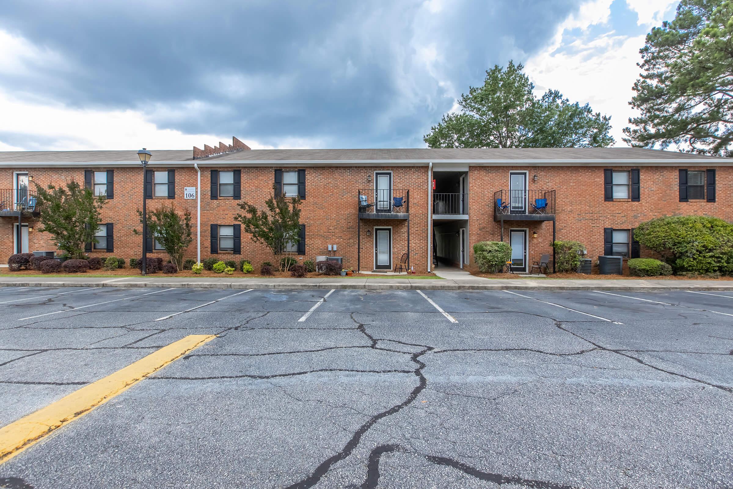 an empty parking lot in front of a brick building