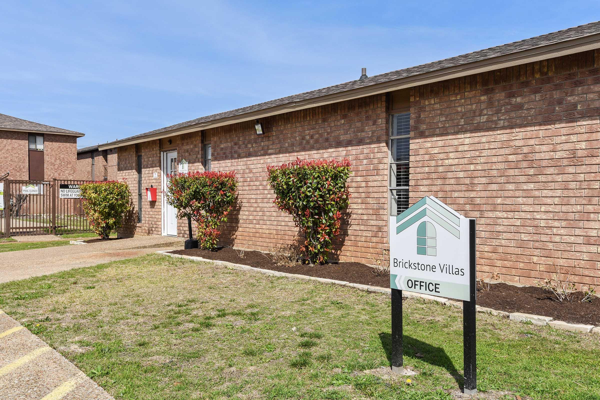 a house that has a sign on a brick building