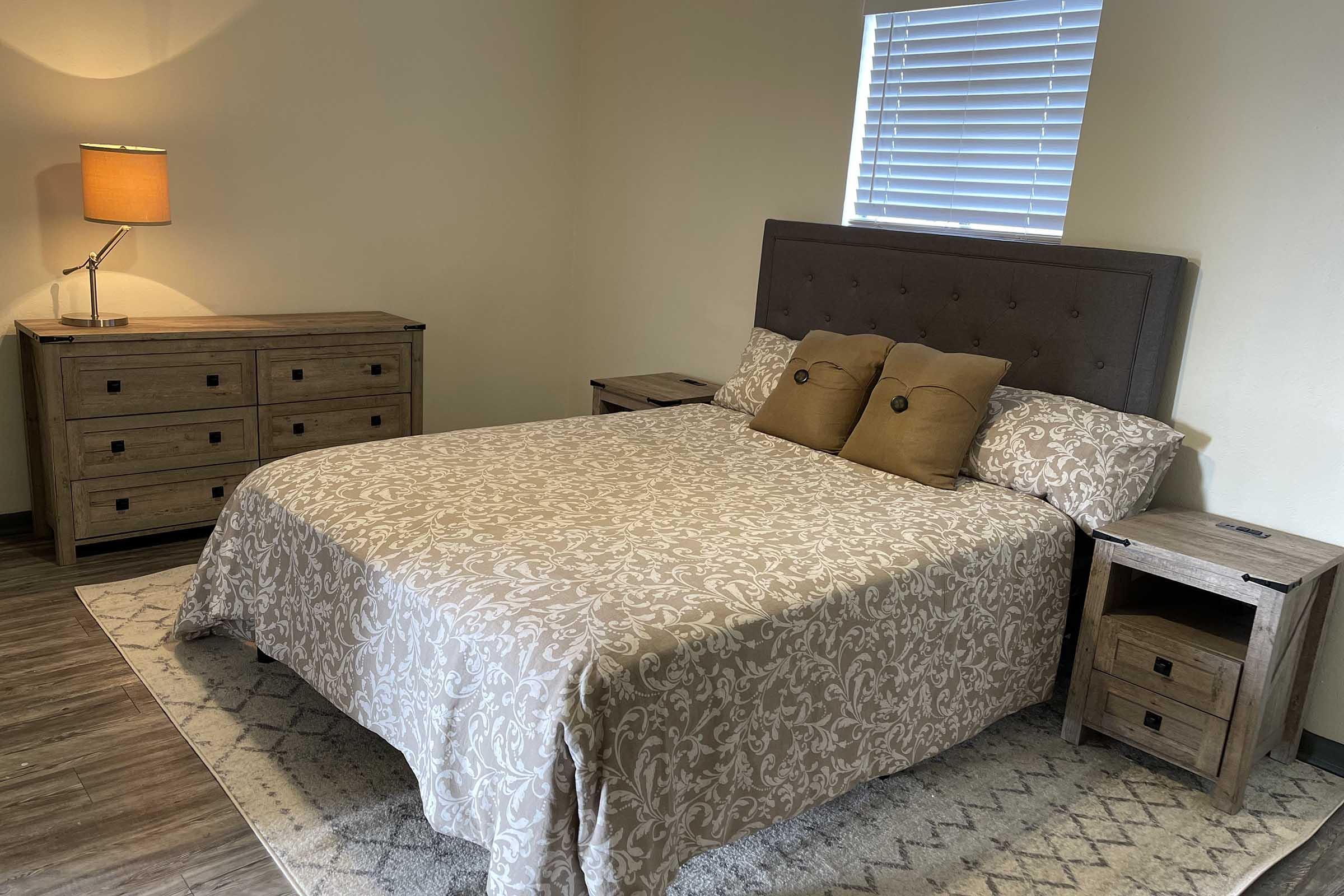 a bedroom with a bed and desk in a room