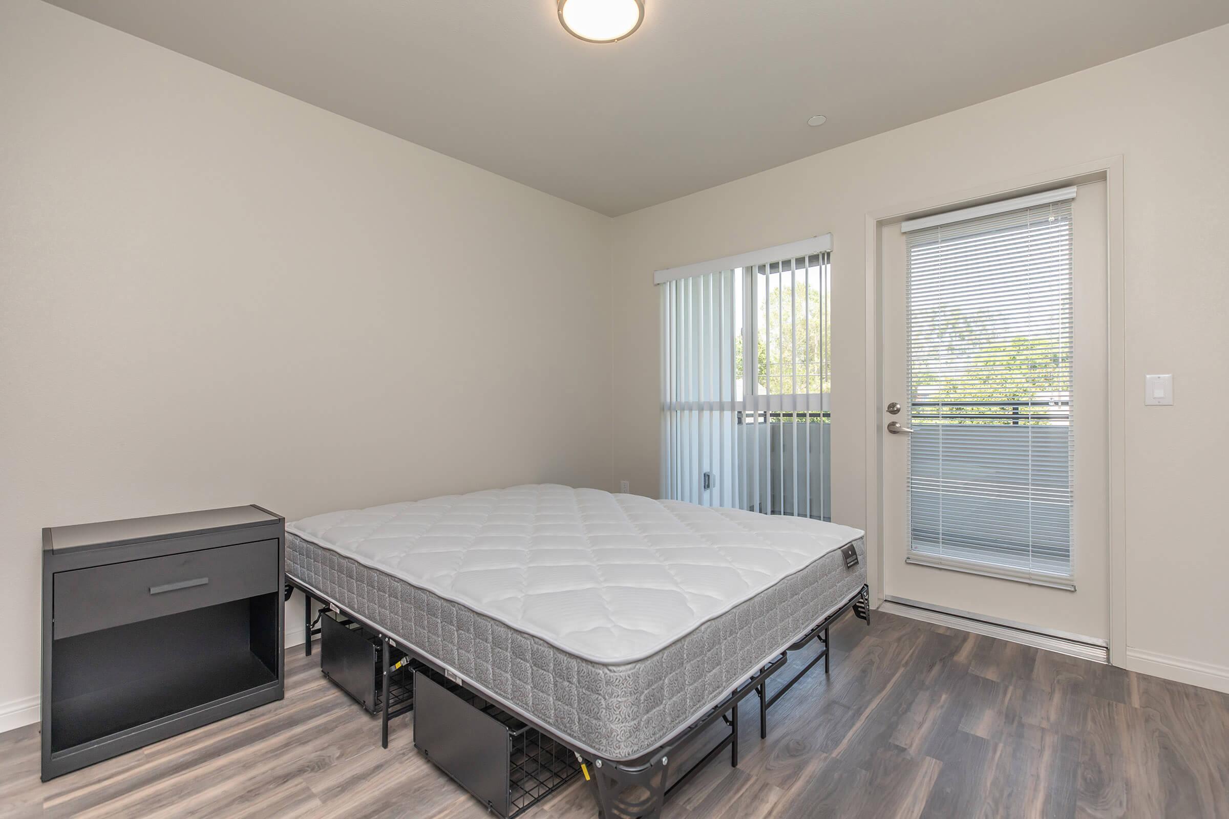 a bedroom with a bed and desk in a room