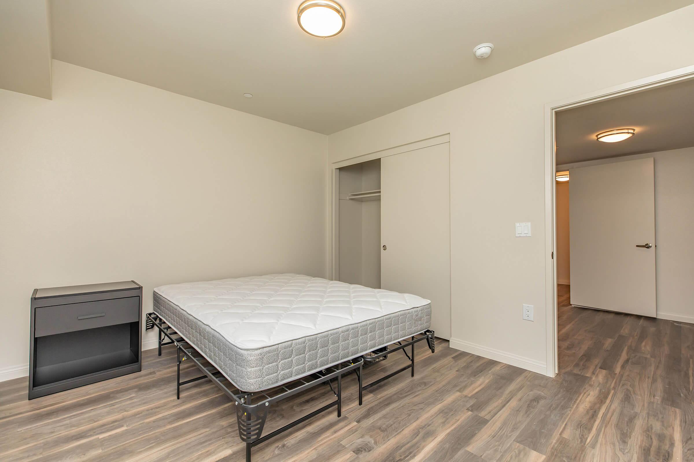 a bedroom with a bed and desk in a room