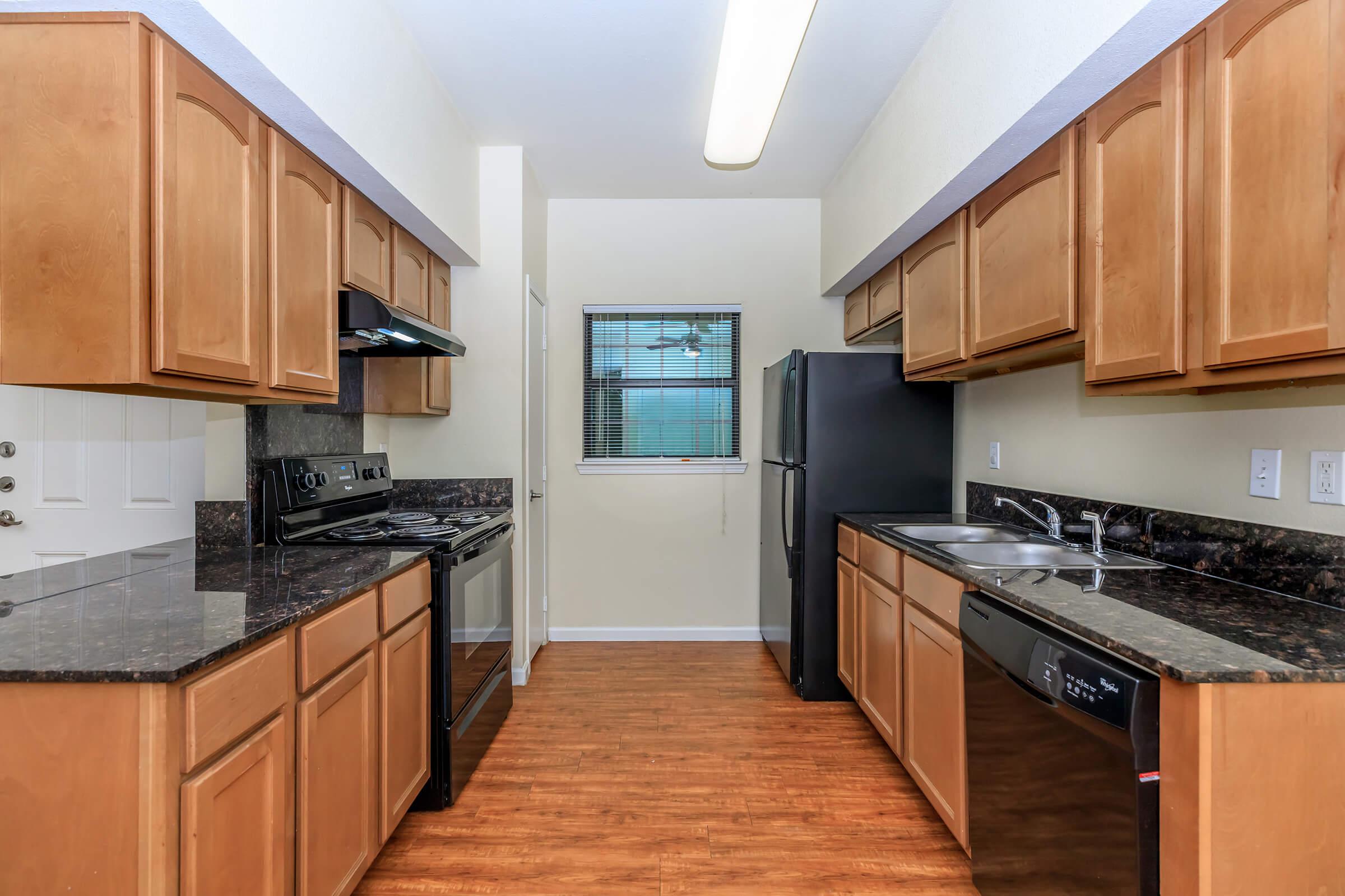 a large kitchen with stainless steel appliances and wooden cabinets