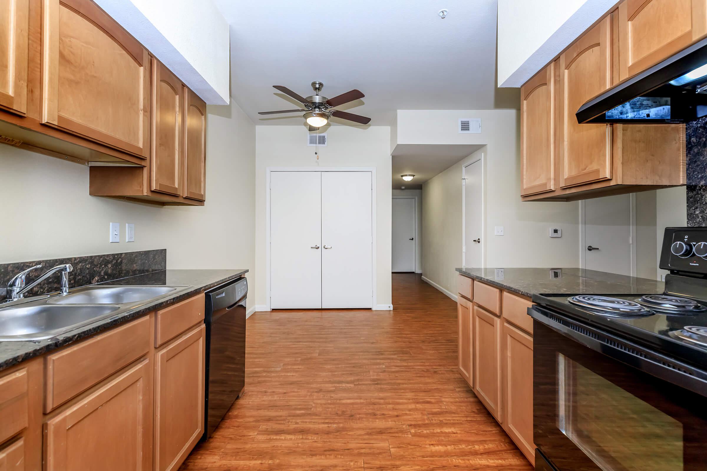 a large kitchen with stainless steel appliances and wooden cabinets