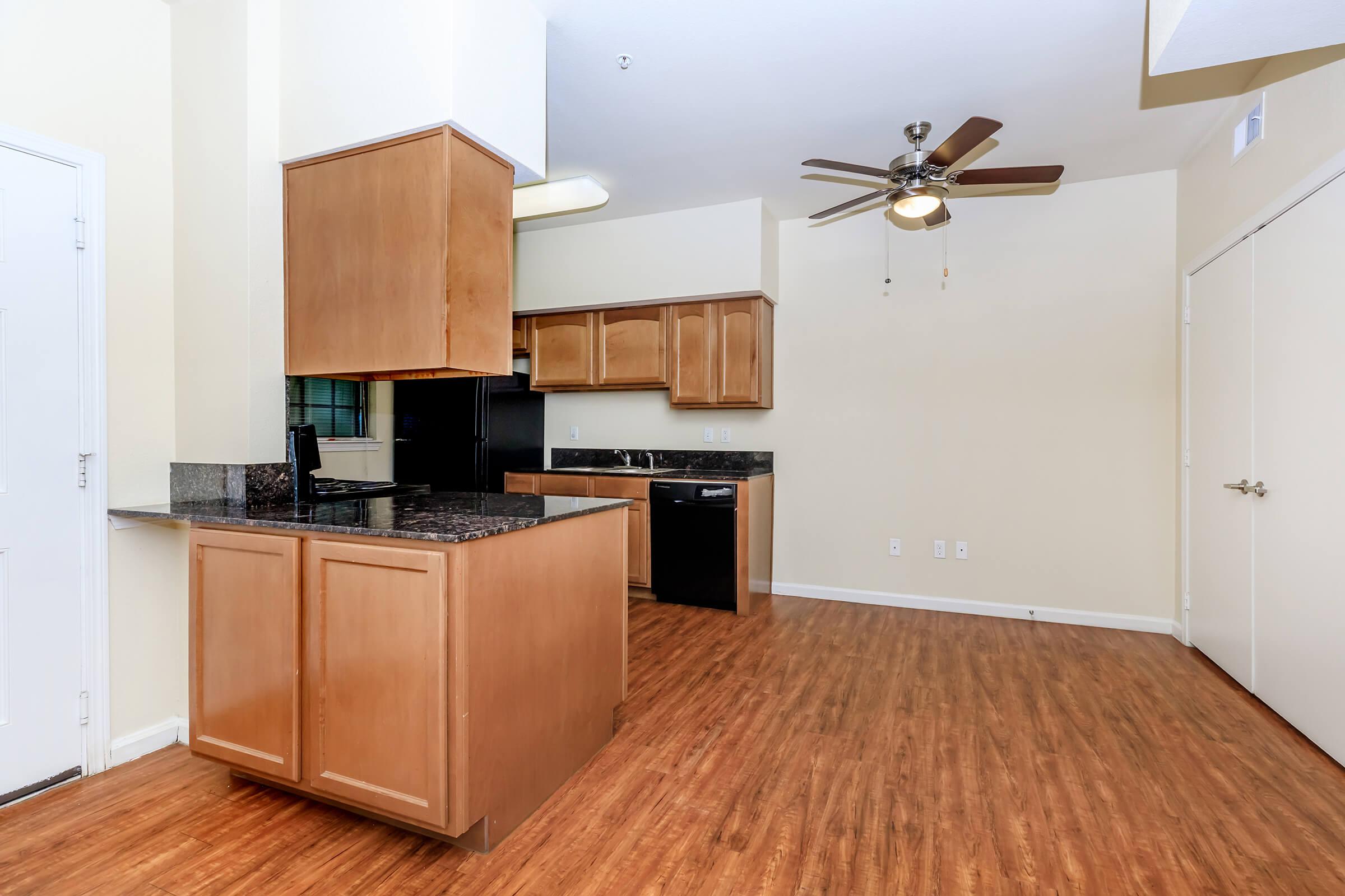 a large kitchen with stainless steel appliances and wooden cabinets