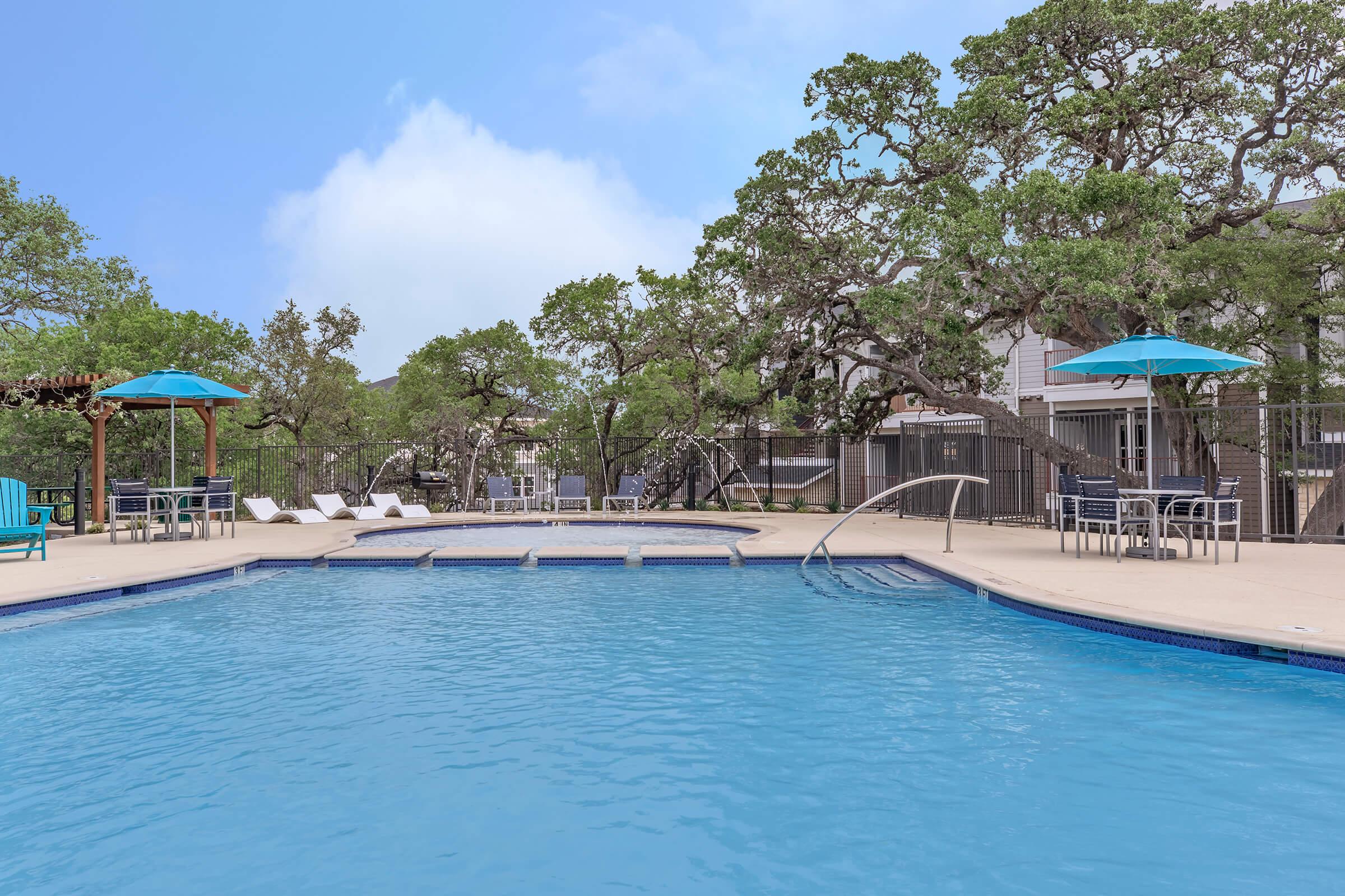 a group of lawn chairs sitting on top of a blue pool of water