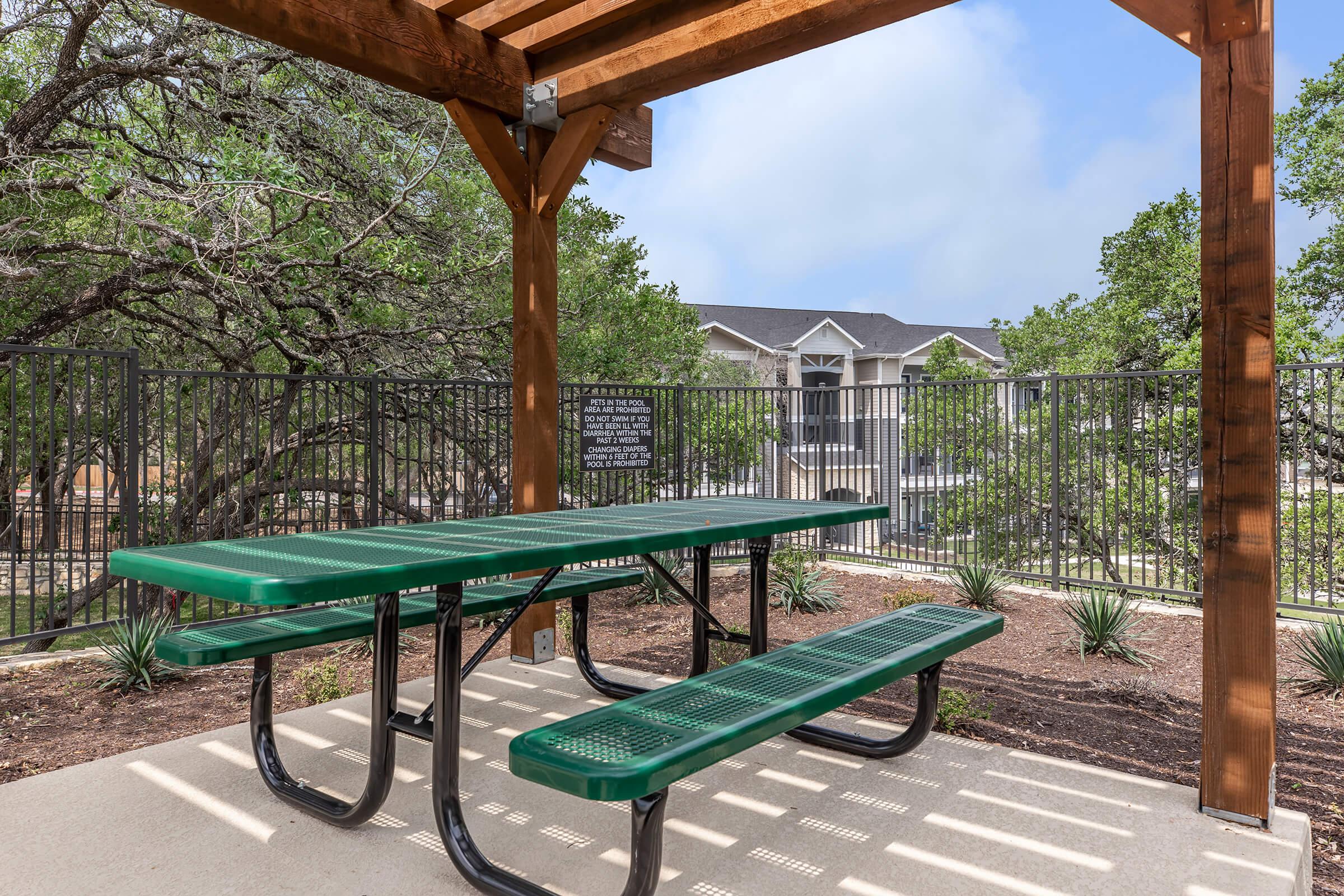 a green bench sitting on top of a wooden fence