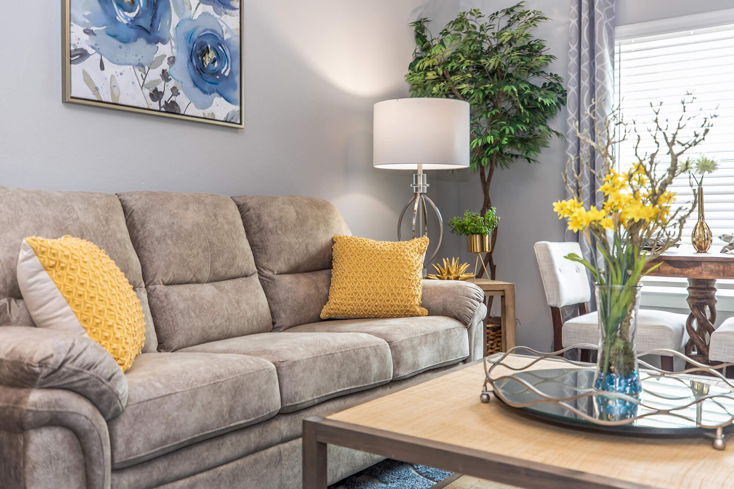 a living room filled with furniture and vase of flowers on a table