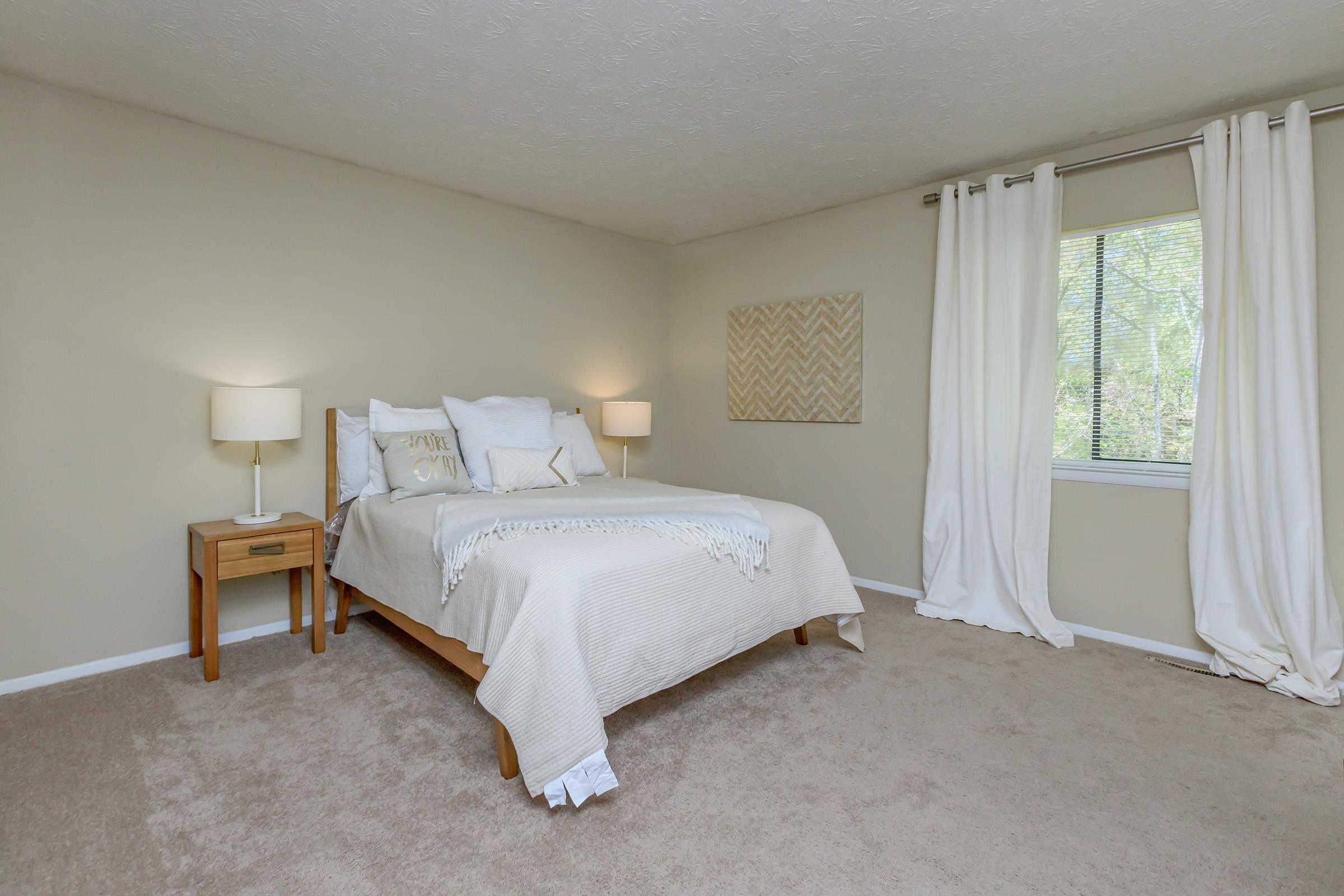 a bedroom with a bed and desk in a room