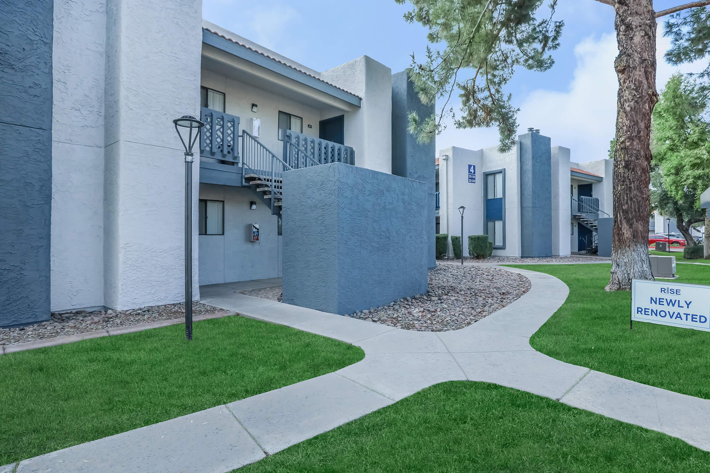 A pathway with landscaping leading to the apartments at Rise at the Meadows.