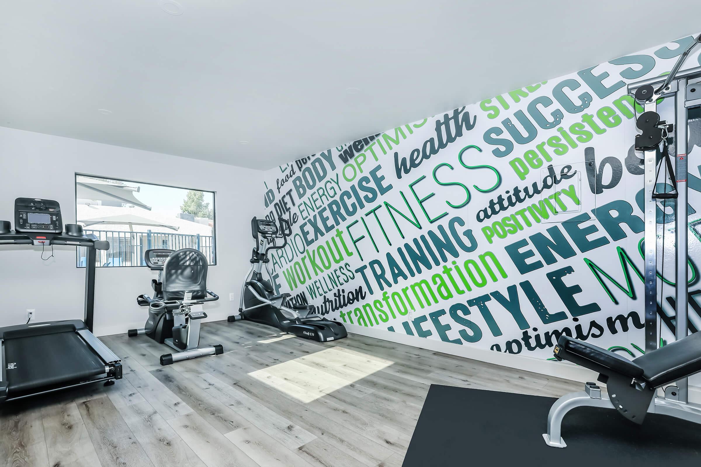 Rise at the Meadows fitness center with equipment and colorful wording on the walls.