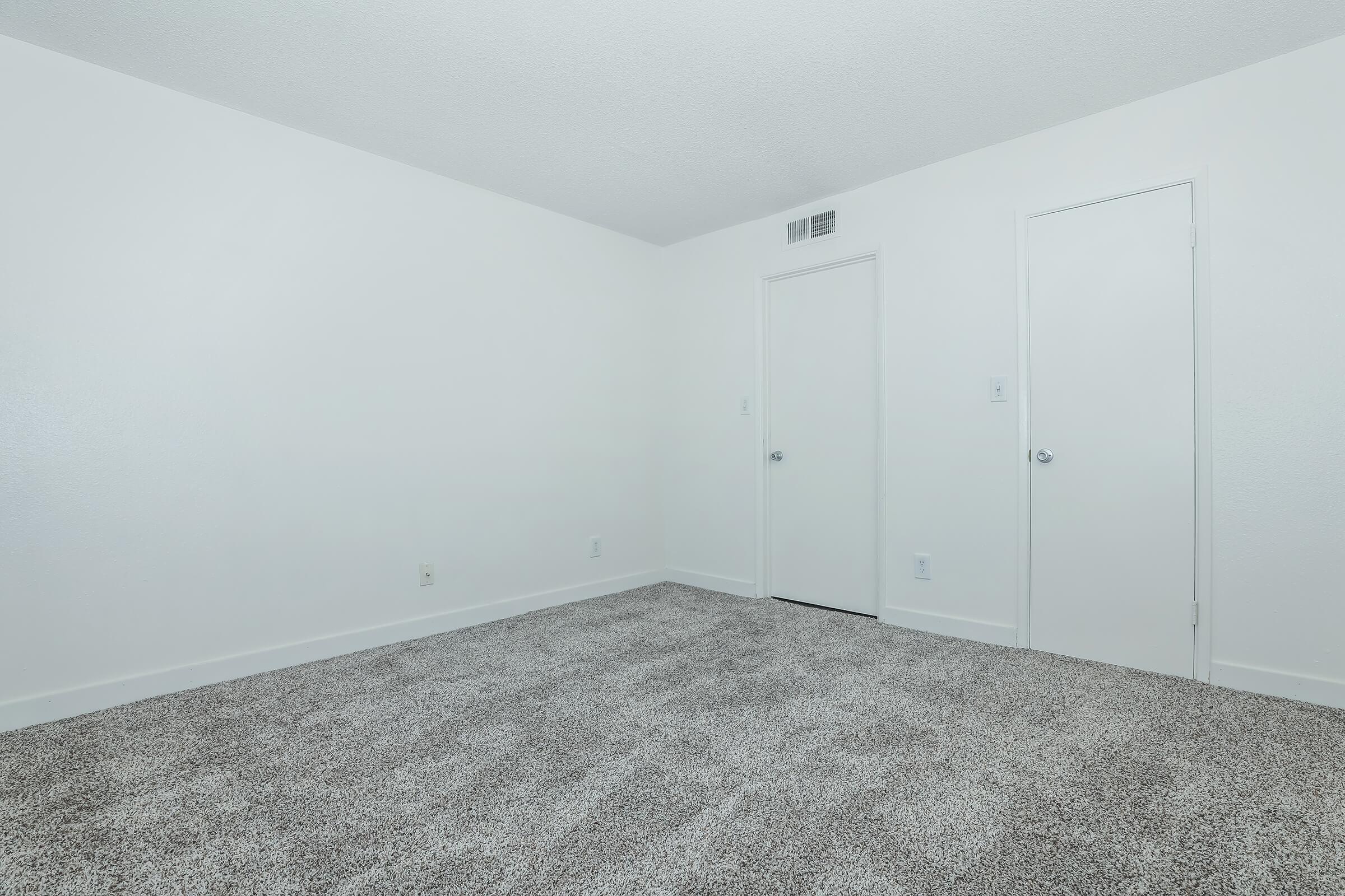 A grey carpeted bedroom at Rise at the Meadows.