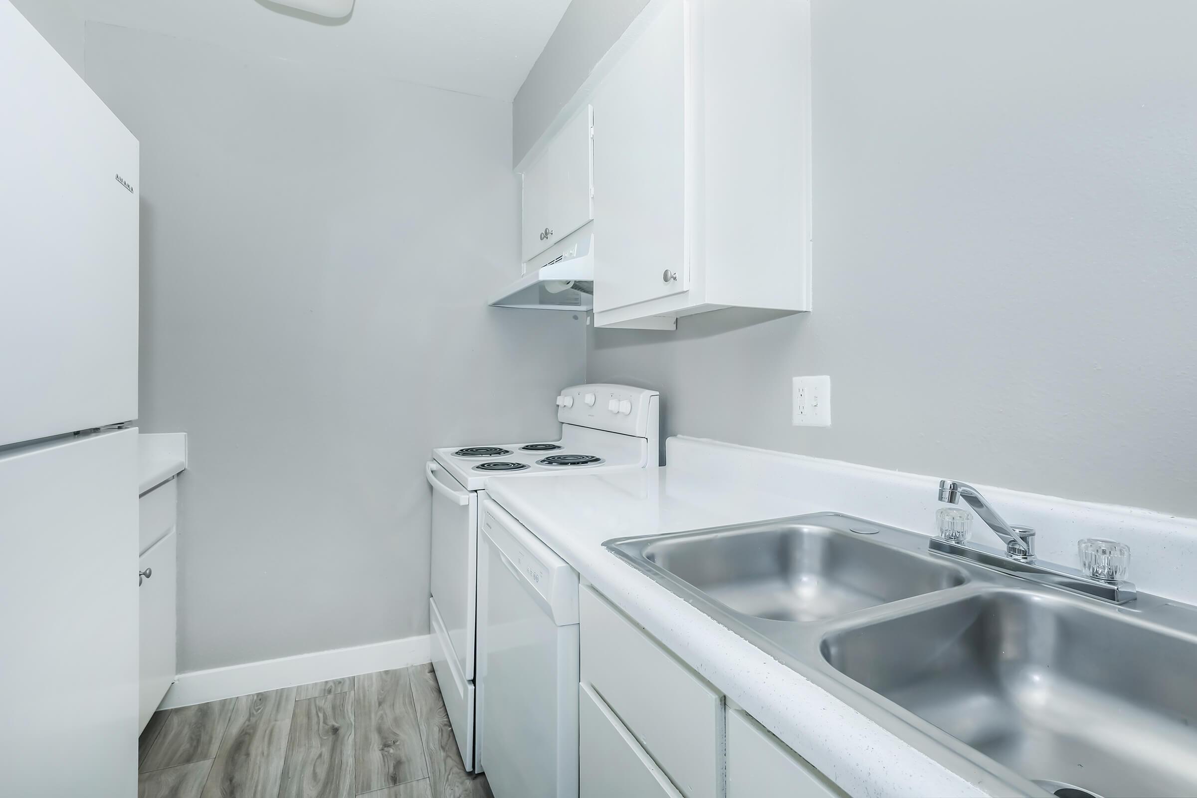 A Rise at the Meadows apartment kitchen with white cabinets and appliances.