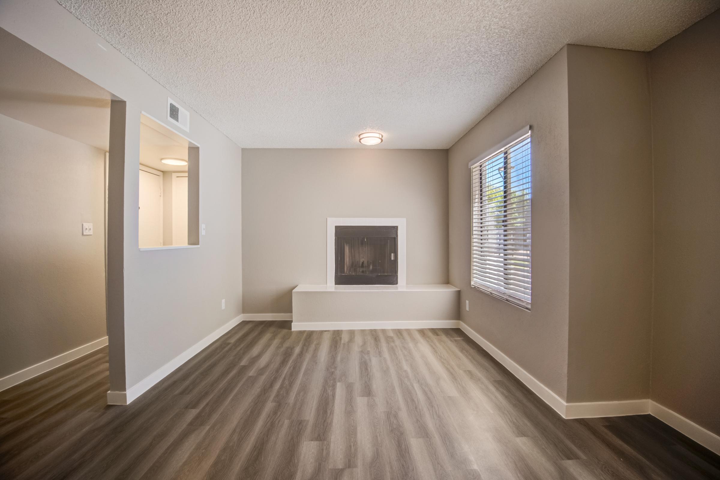 An apartment living area with a fireplace at Rise at the Meadows.