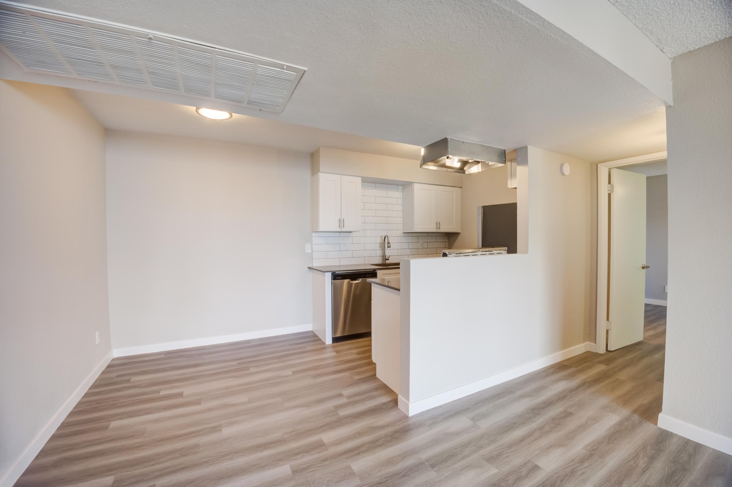An open concept apartment with a dining area and a kitchen at Rise at the Meadows.