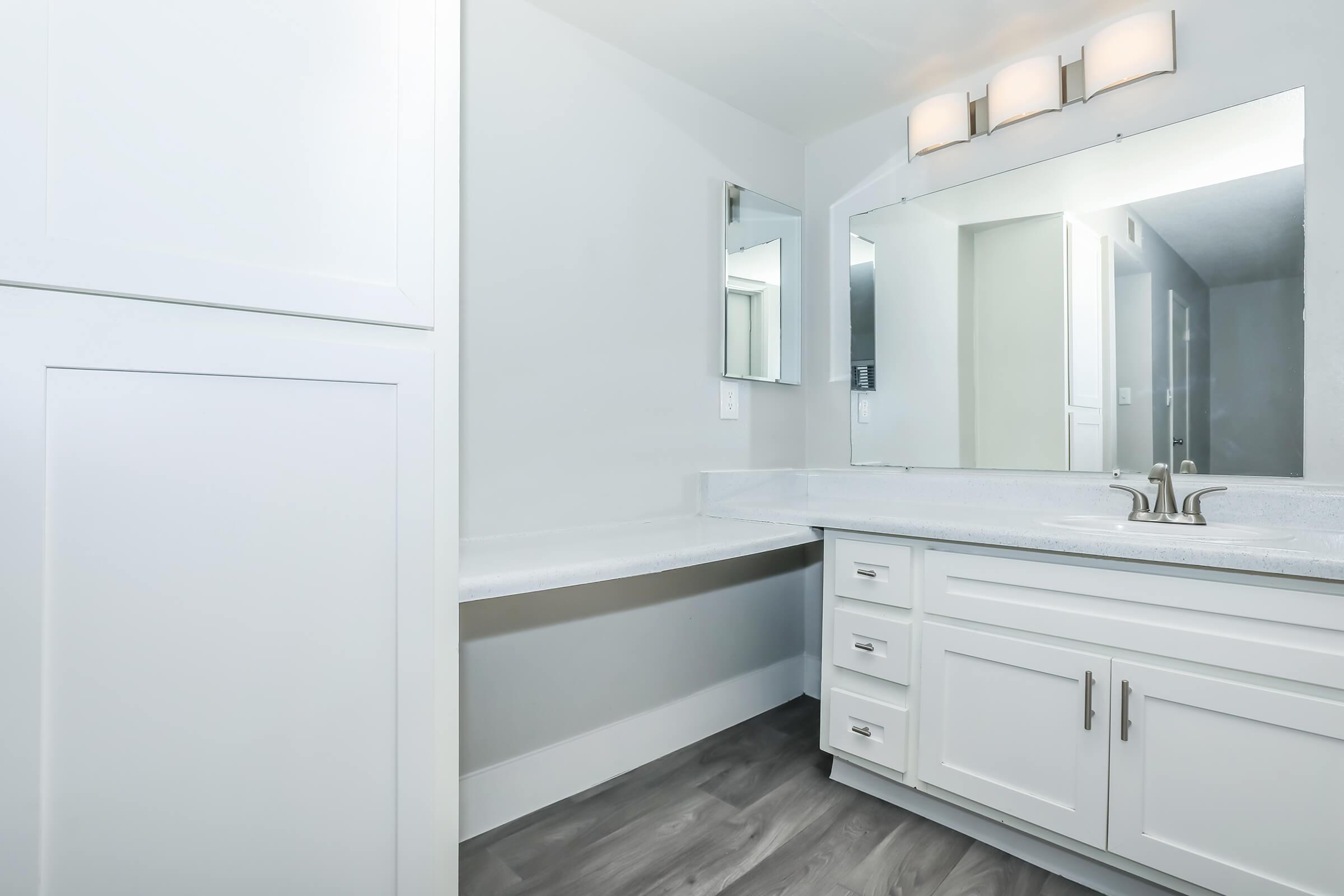 A a bathroom at Rise at the Meadows with white cabinets.