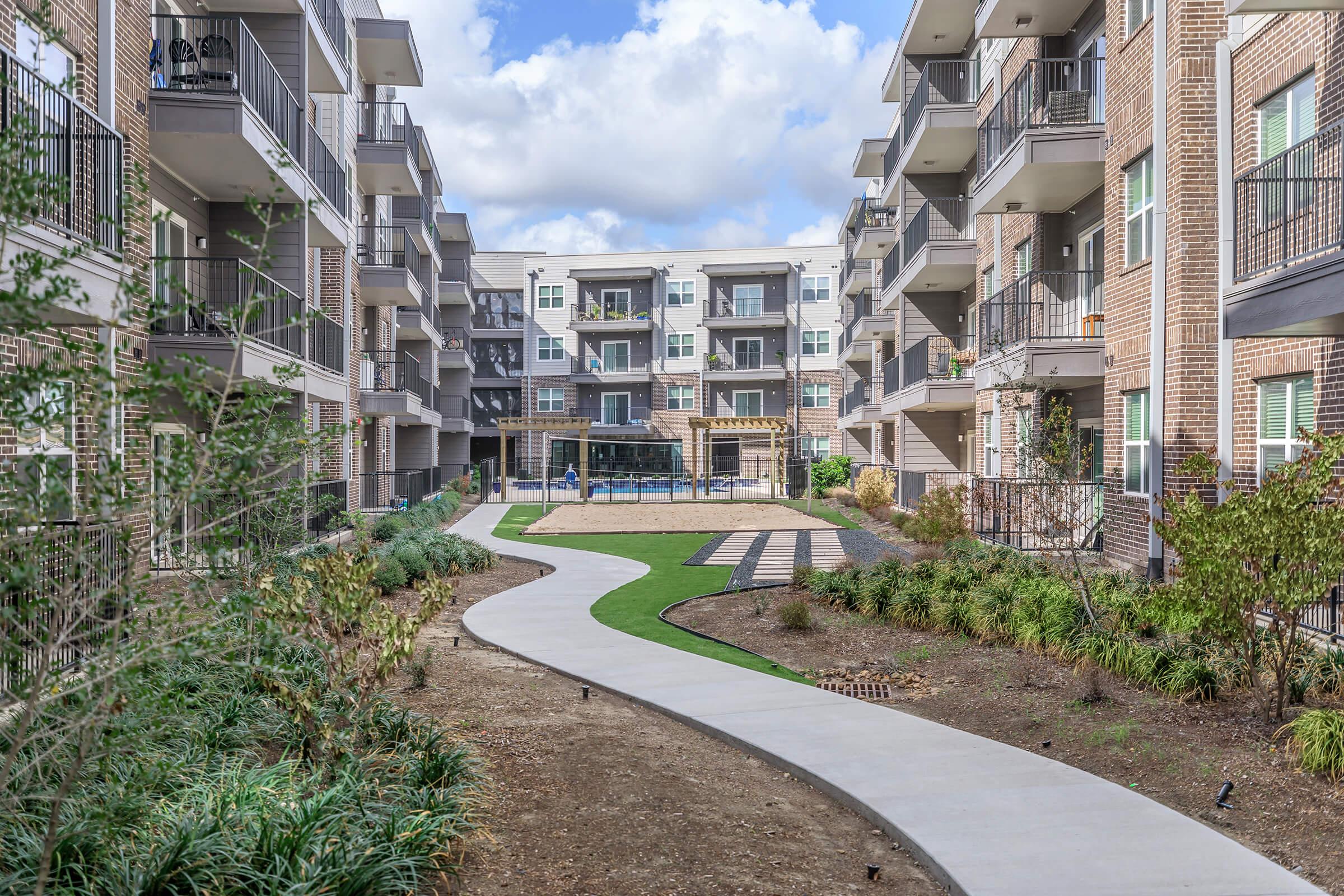 a path with trees on the side of a building