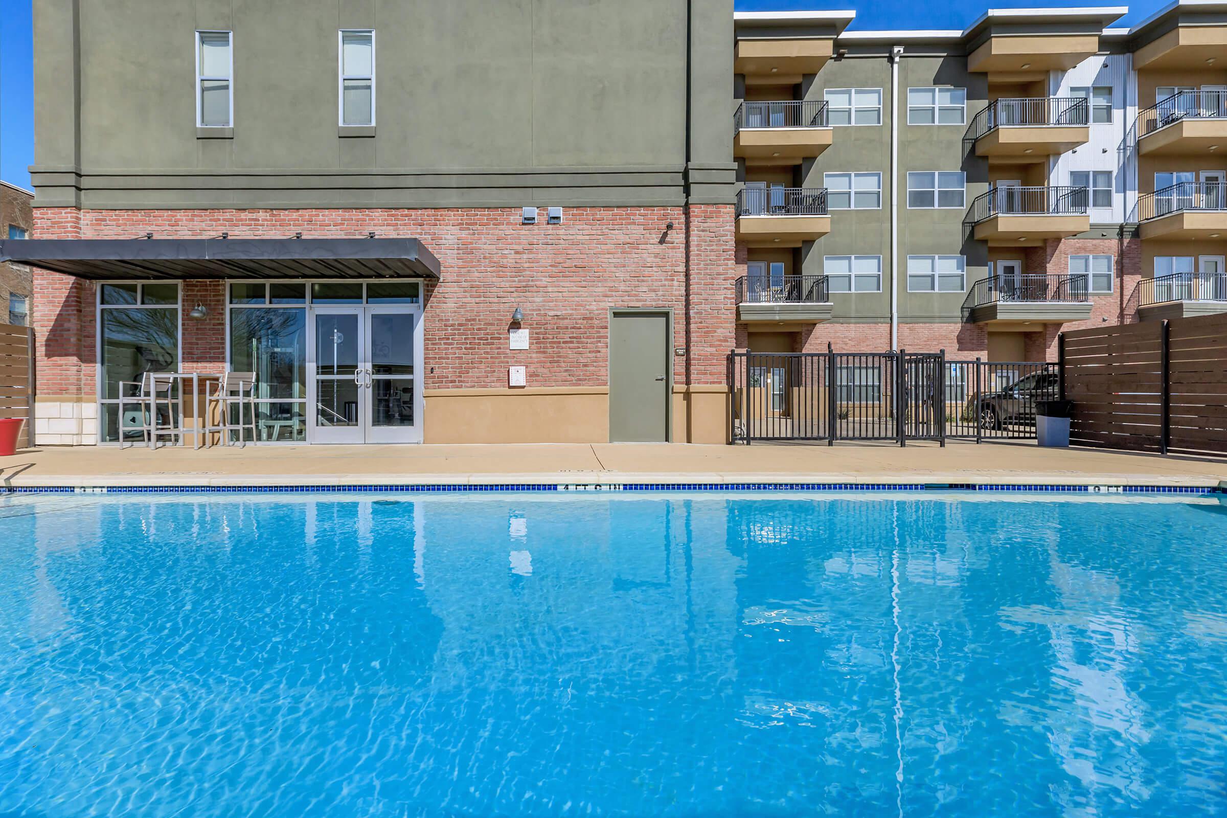 a blue pool of water in front of a building